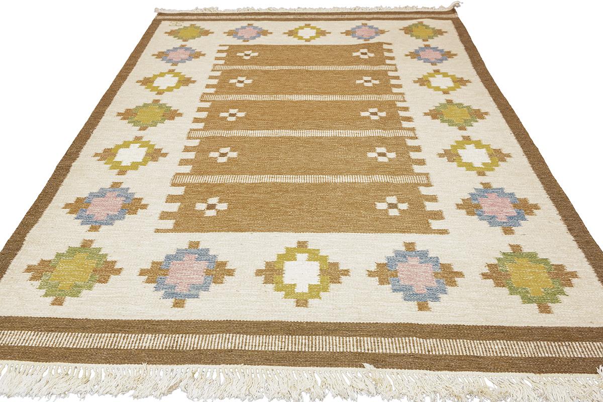 Célébrez l'art de l'artisanat nordique avec cet exquis tapis scandinave Rollakan, signé par l'artiste. Cette pièce est une superbe illustration de la technique de tissage traditionnelle suédoise, appréciée depuis des générations pour sa simplicité,