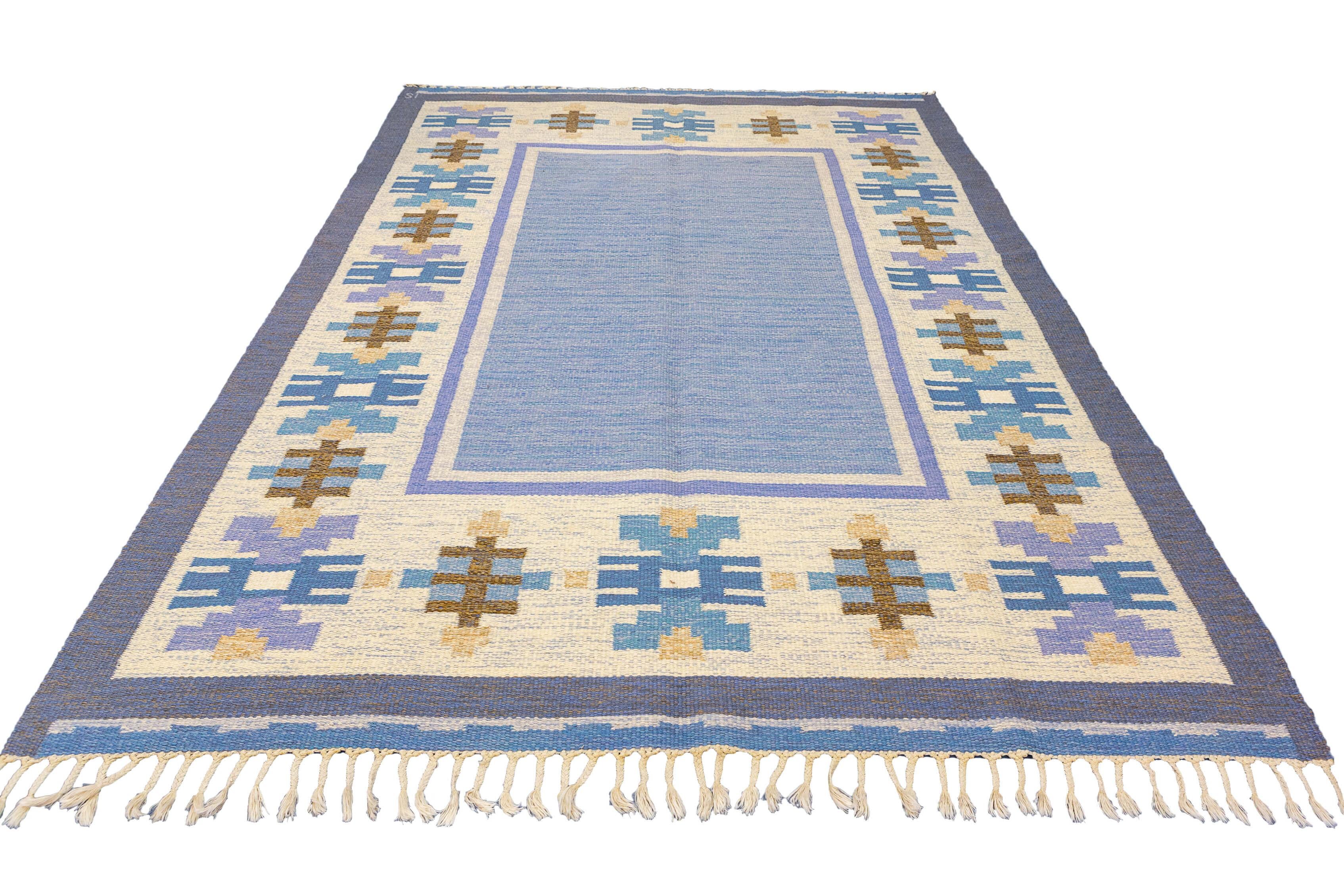 This captivating Scandinavian Rollakan Swedish Rug features a soft color palette encompassing shades of blue, beige, and brown, creating a serene and inviting atmosphere. The combination of these gentle hues evokes a sense of tranquility and