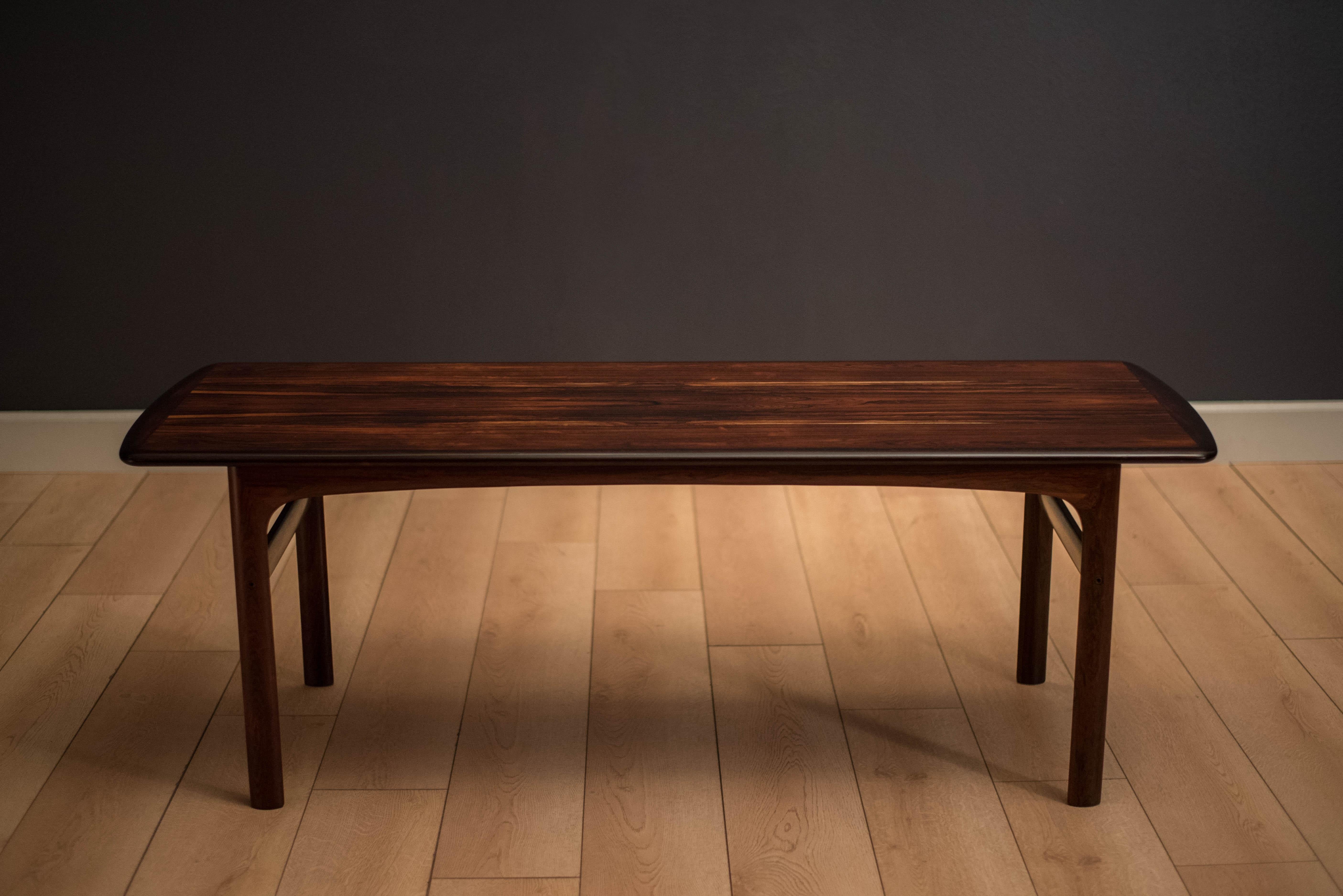 Mid-Century Modern coffee table manufactured by Westnofa of Norway. Table top features gorgeous rosewood grains wrapped with solid wood edge banding.