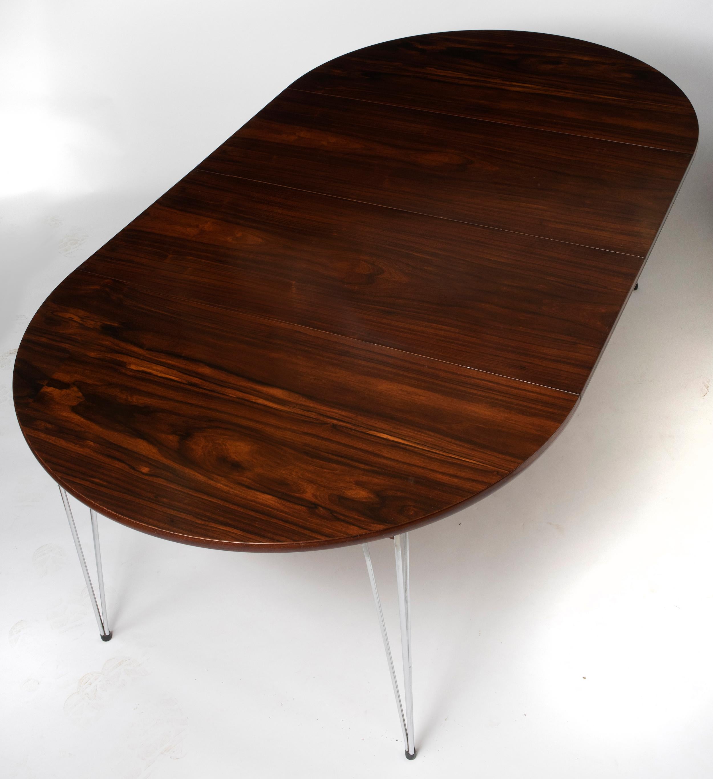 A Scandinavian rosewood dining table by Hans Brattrud.
The extending top with a hidden two part leaf. Upon a chromium plated base.
Ebonized stretcher.
Unmarked.
Norway circa 1957
Measures: 73 cm high x 137 cm wide (198 cm extended) x 92 cm deep.
 