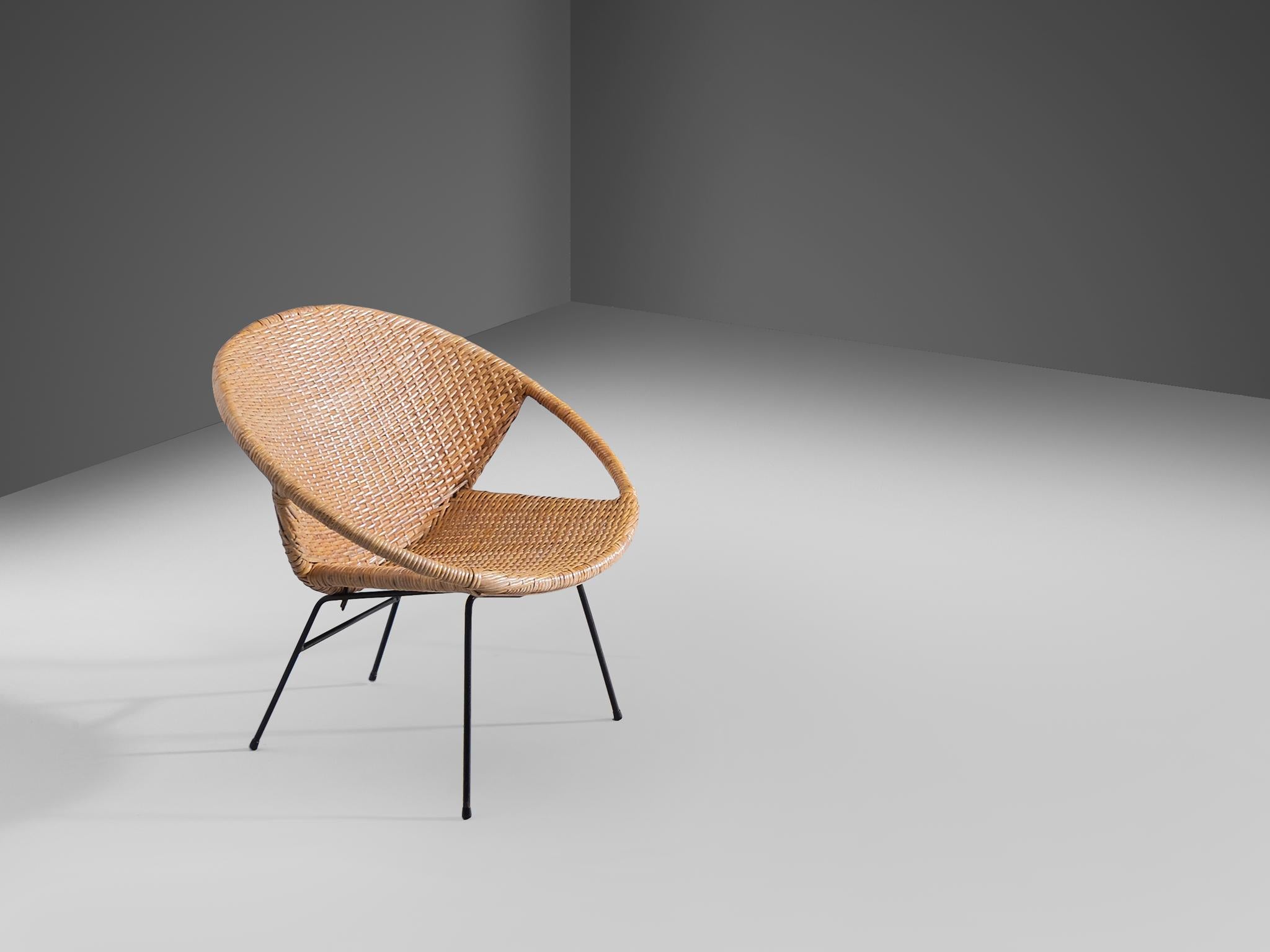 Side chair, rotan, lacquered metal, Scandinavia, 1960s

A circular frame positioned at a diagonal angle forms the foundation of this design. The seat and backrest are set around this circular base, while the frame also serves as the armrest. The