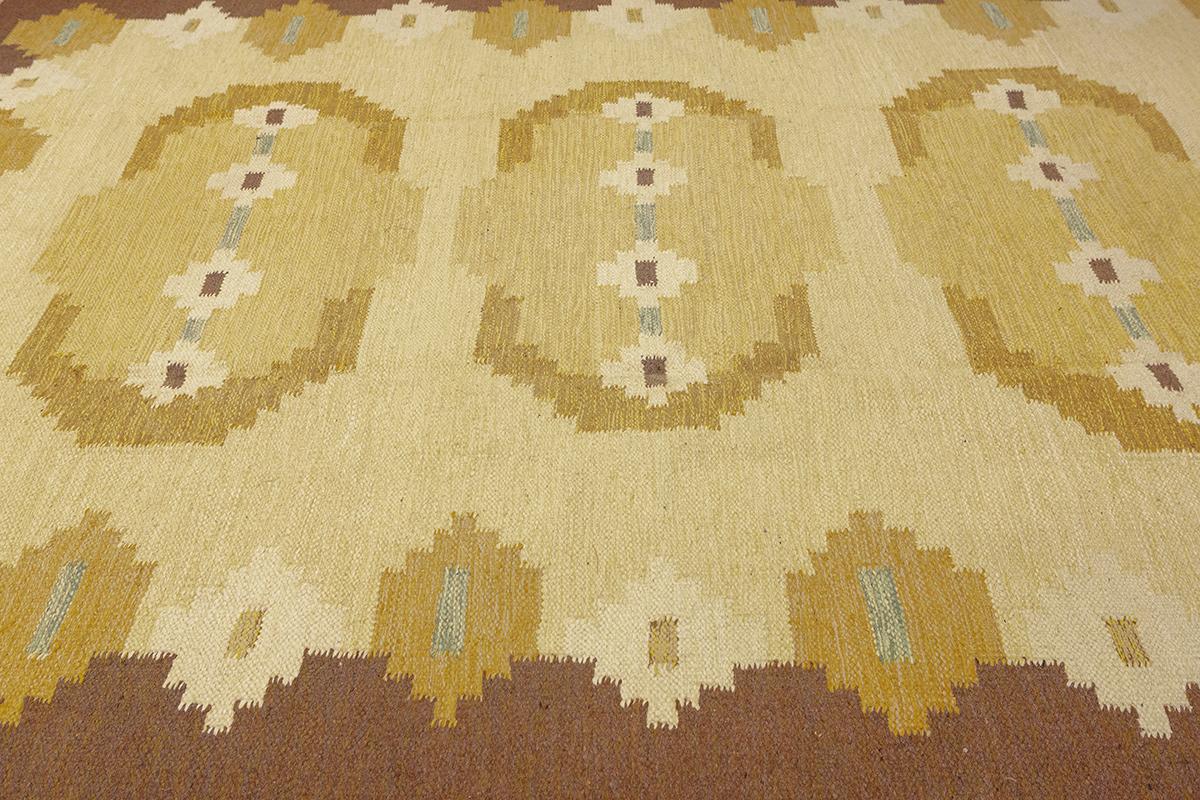 This vintage Scandinavian rug features a harmonious blend of soft yellow, beige, and brown tones. The geometric patterns are typical of Scandinavian design, showcasing a minimalist yet warm aesthetic. The rug's symmetrical layout, with repeating