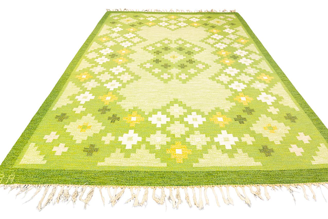 The Rollakan Swedish rug with a cross motif design is a unique and special piece that showcases the timeless beauty of Scandinavian craftsmanship. The combination of the vibrant green color and the cross motif creates a visually striking and