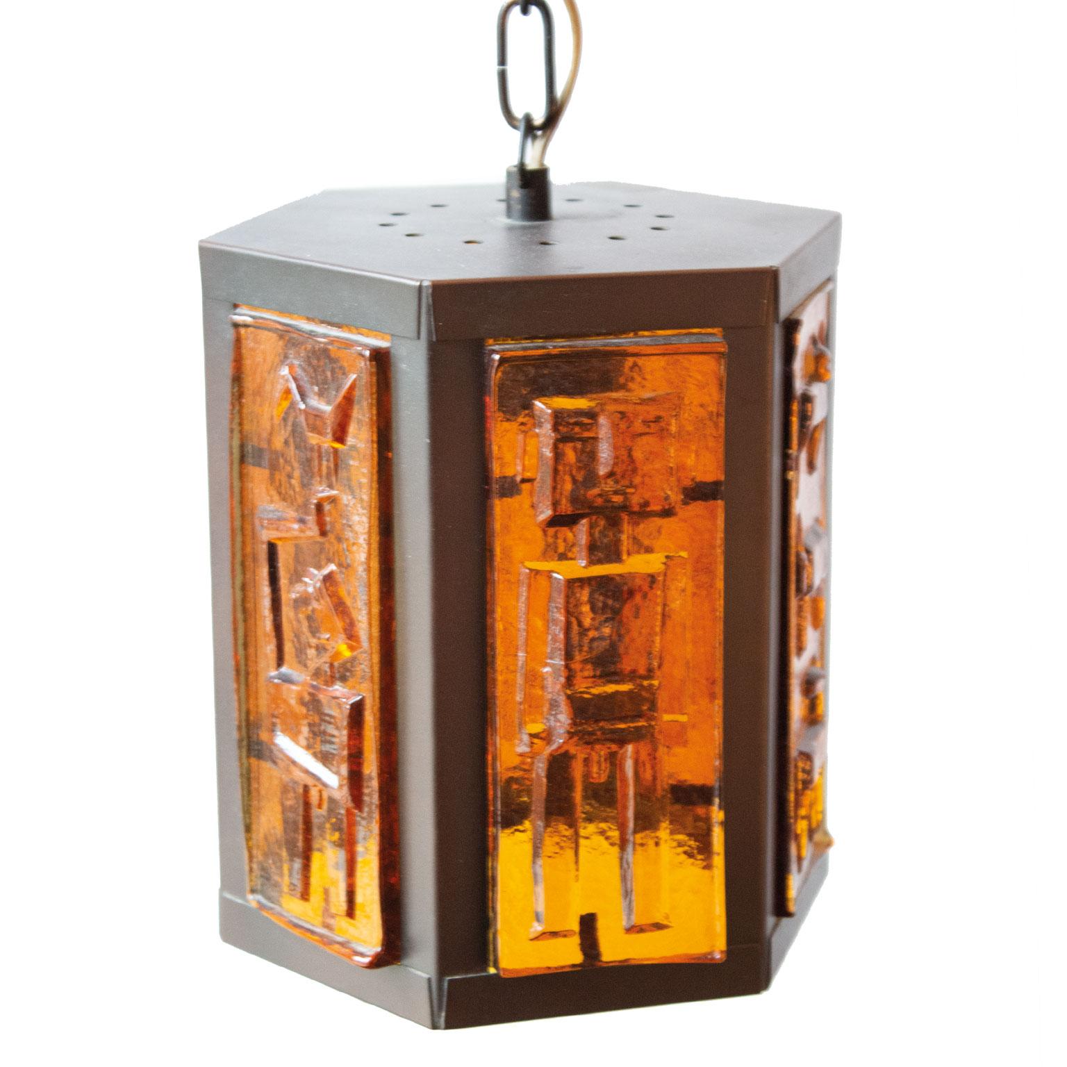 Swedish rustic colored glass pendant by Erik Höglund 1960s for Boda Bruk in Sweden. Material are metal with six thick cast brown glass slab walls with motives of paradise with Adam and Eva. Beautiful warm orange light when lit. Made in the 1960s.
