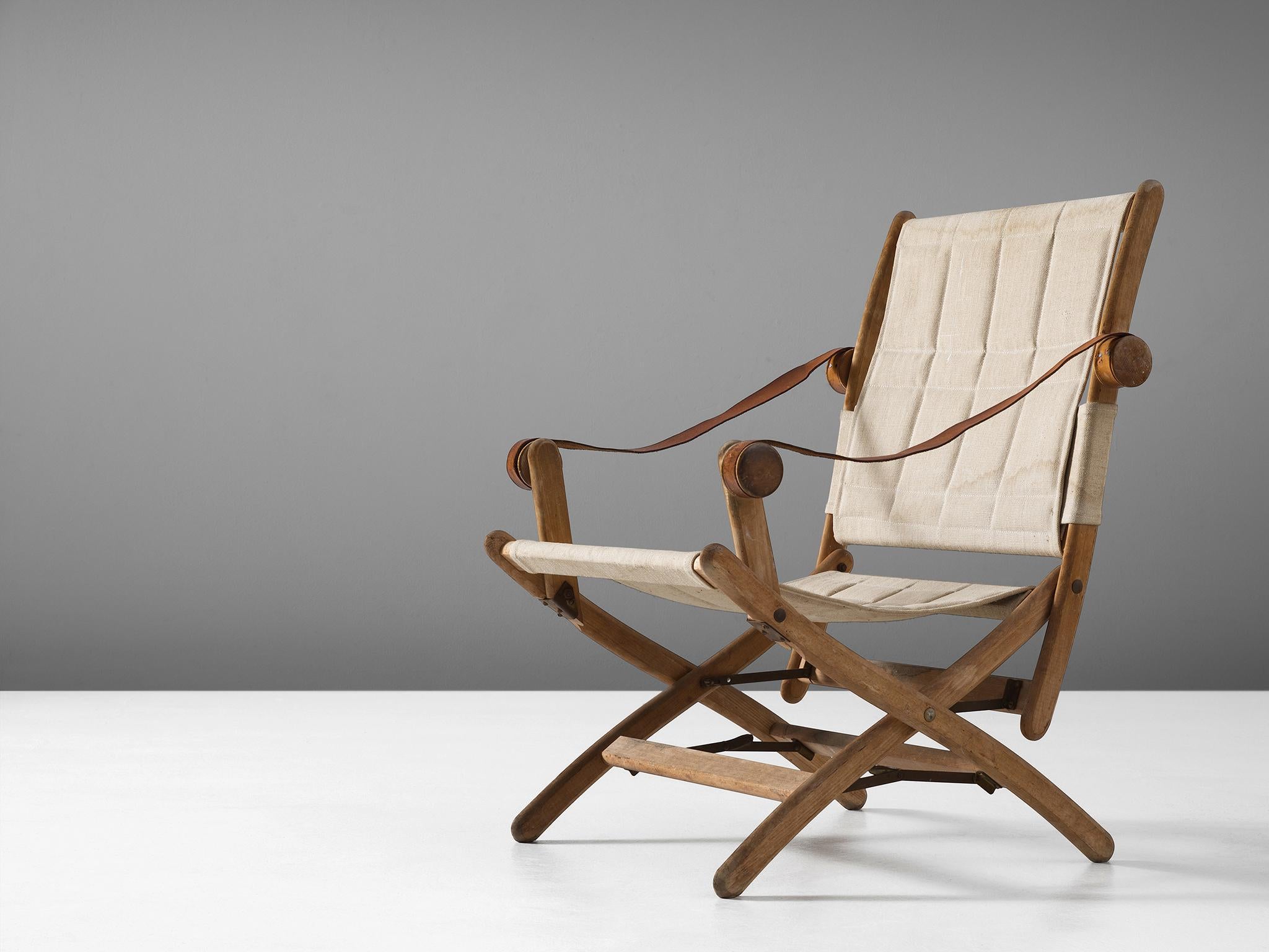 Folding chair in beech, leather and canvas, Scandinavia, 1950s.

Interesting safari chair with beautiful cognac leather armrests. The wooden frame in beech shows nice details, so as the knobs for the armrests. The legs are X-shaped with