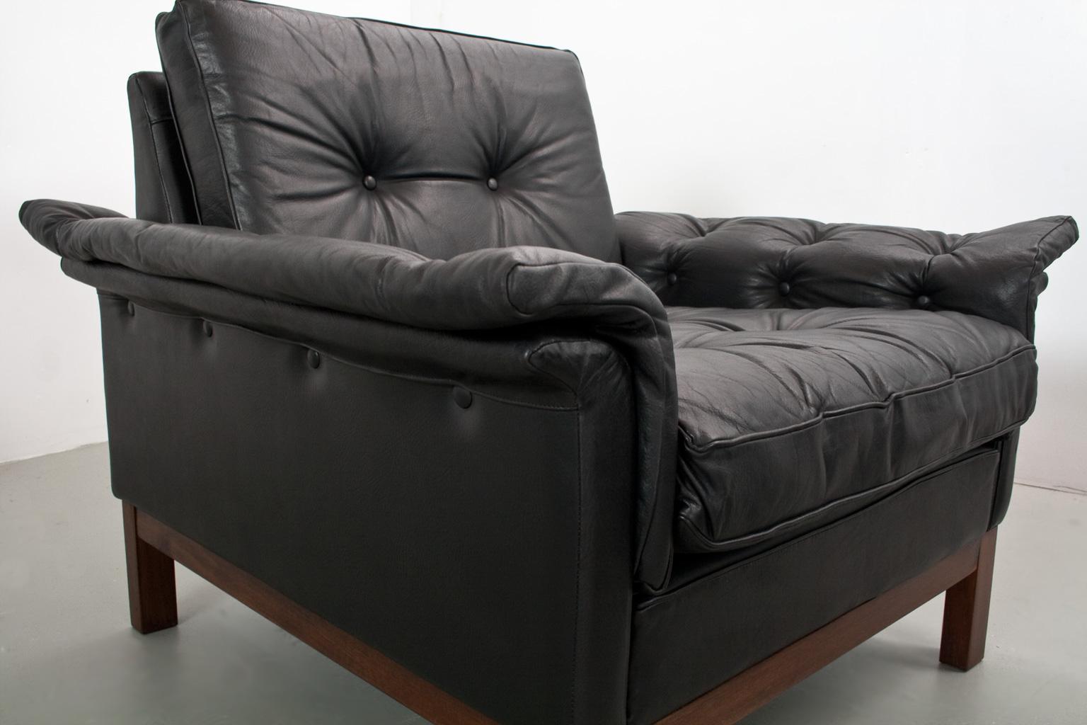 Scandinavian Modern comfortabel and luxurious lounge chairs in black leather in original and very good condition. Originated from Denmark 1950s. Designer unknown, yet the pieces feature traits of the style of Knut Saeter, Folke Ohlssen or Juul