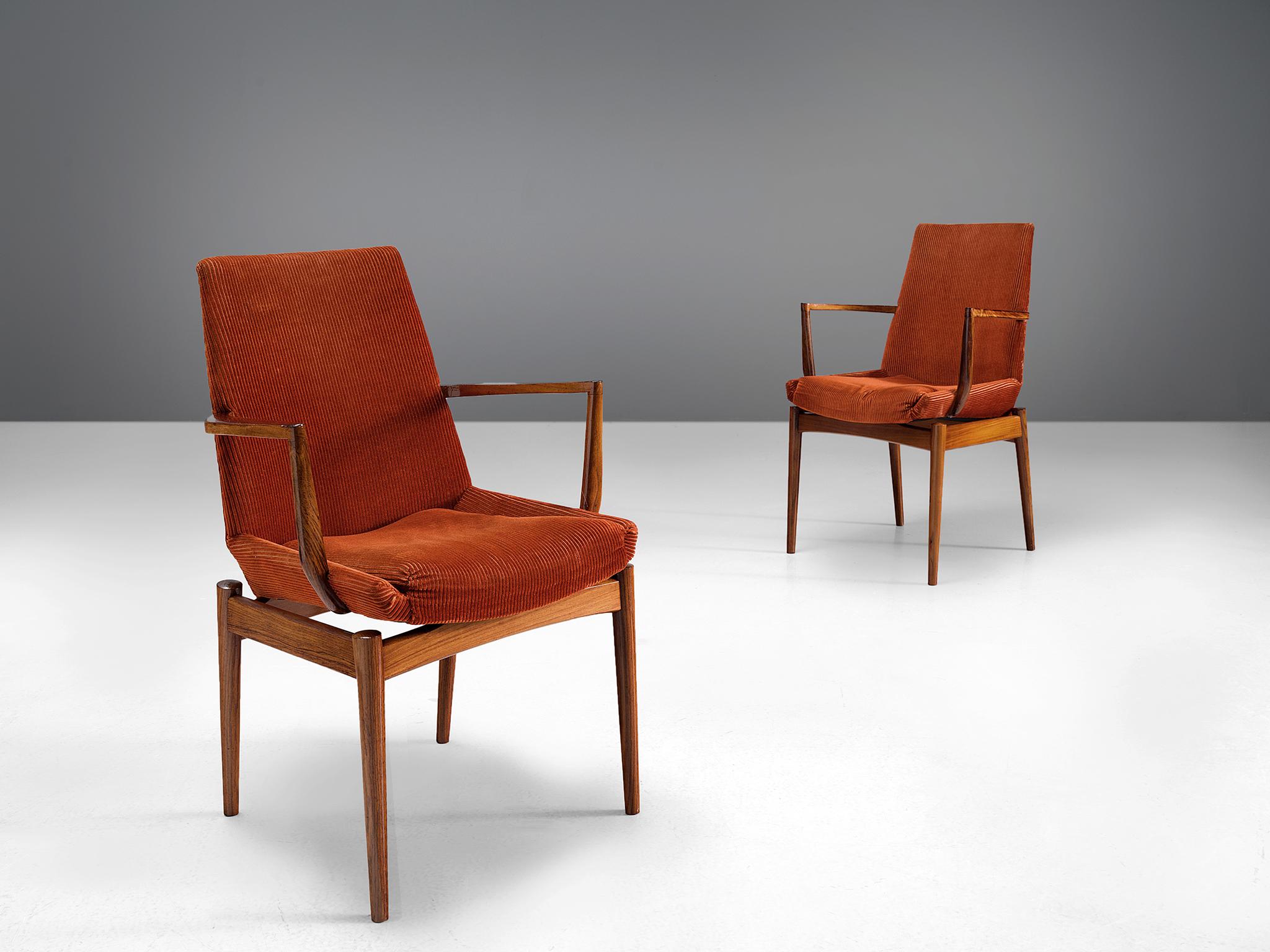 Side chairs, rosewood, red orange corduroy, Scandinavia, circa 1955.

Two chairs is sensuous, sculptural and elegant. The chairs feature high backs, and dramatically high and sculpted armrests. The curved, tapered legs are another main feature of