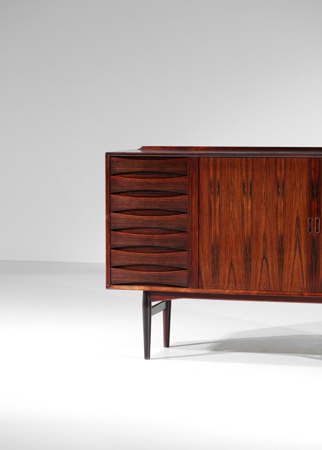 Superb Scandinavian sideboard of the Danish designer Arne Vodder edited by Sibast in the 1960s. Structure of the sideboard and the base in solid wood and veneer. The enfilade is composed of a column of 7 drawers and two sliding doors opening on a