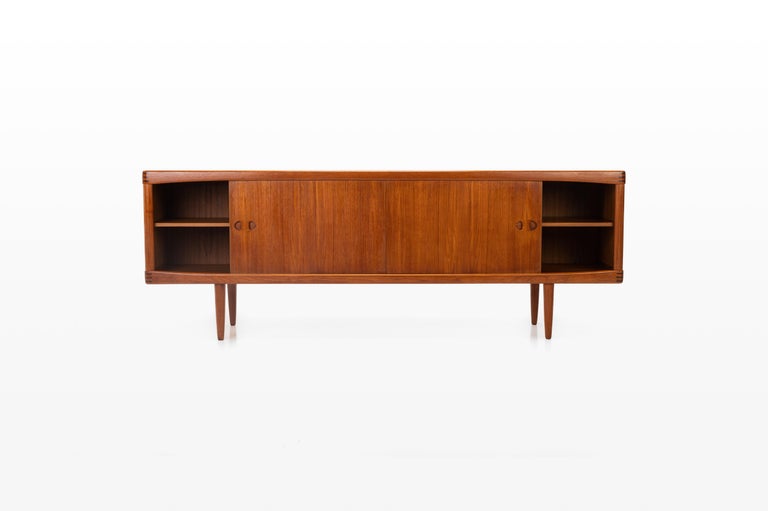This sideboard was designed by Henry W. Klein for Bramin, Denmark 1960s. There are two sliding doors, four drawers and shelves. The sideboard is of very high quality and in very good condition. Finished in teak.
 