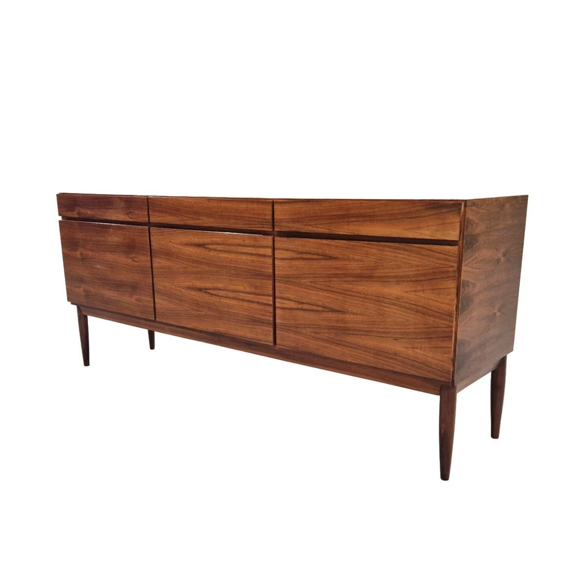 Superb Scandinavian sideboard  by the famous Danish architect IB Kofod Larsen. This piece of furniture is a rare three-door interpretation of the large FA66 sideboard produced by Faarup Möbelfabrik. The interior in light wood has a series of drawers