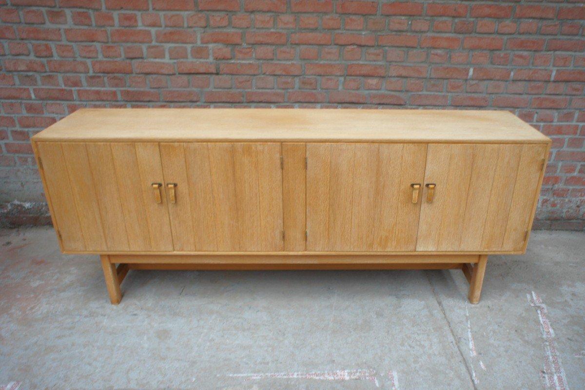 Rare light oak sideboard by Kurt Ostervig for KP Mobler. This row opens with 4 hinged doors, equipped with light leather pulls, revealing 4 drawers and height-adjustable shelves.