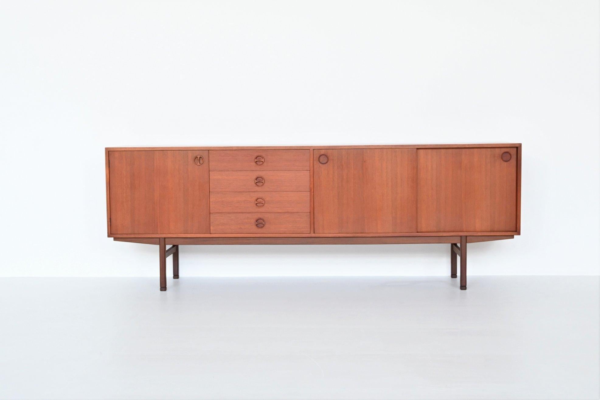 Wonderful Scandinavian sideboard designed by unknown designer or manufacturer, Denmark 1960. This well-crafted cabinet features four drawers in the middle, two sliding doors on the right and another door on the left with shelves behind. Some