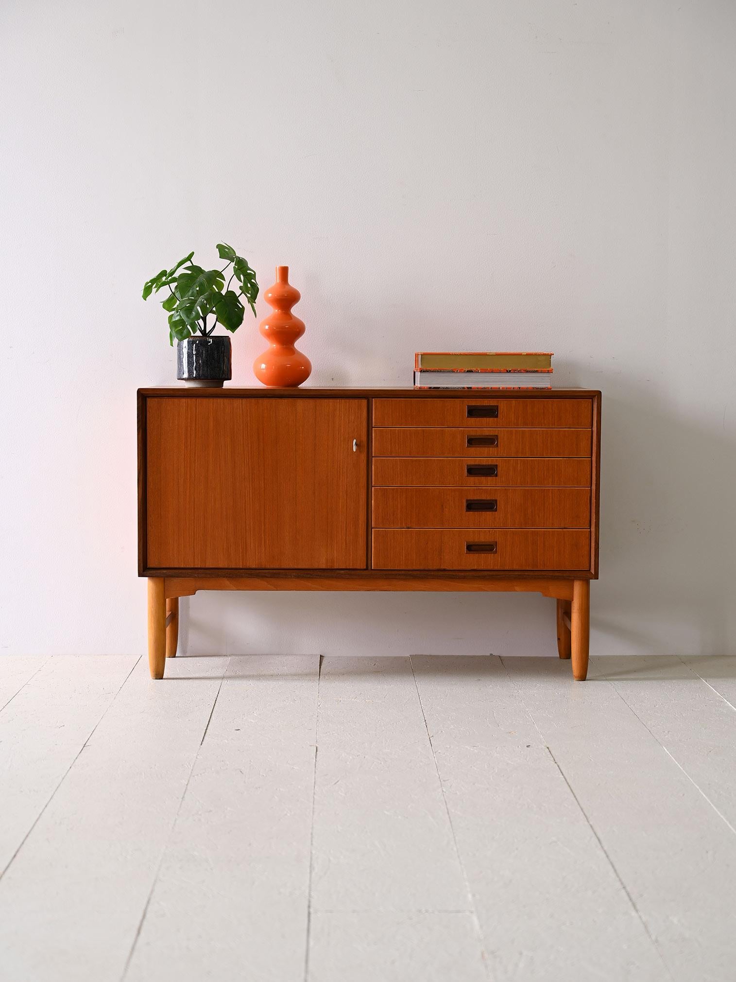 Original 1960s vintage sideboard cabinet with drawers and storage compartment.

There are 4 drawers with a carved wooden handle. The storage compartment is closed by a hinged door equipped with a lock.
An elegant and versatile piece of furniture