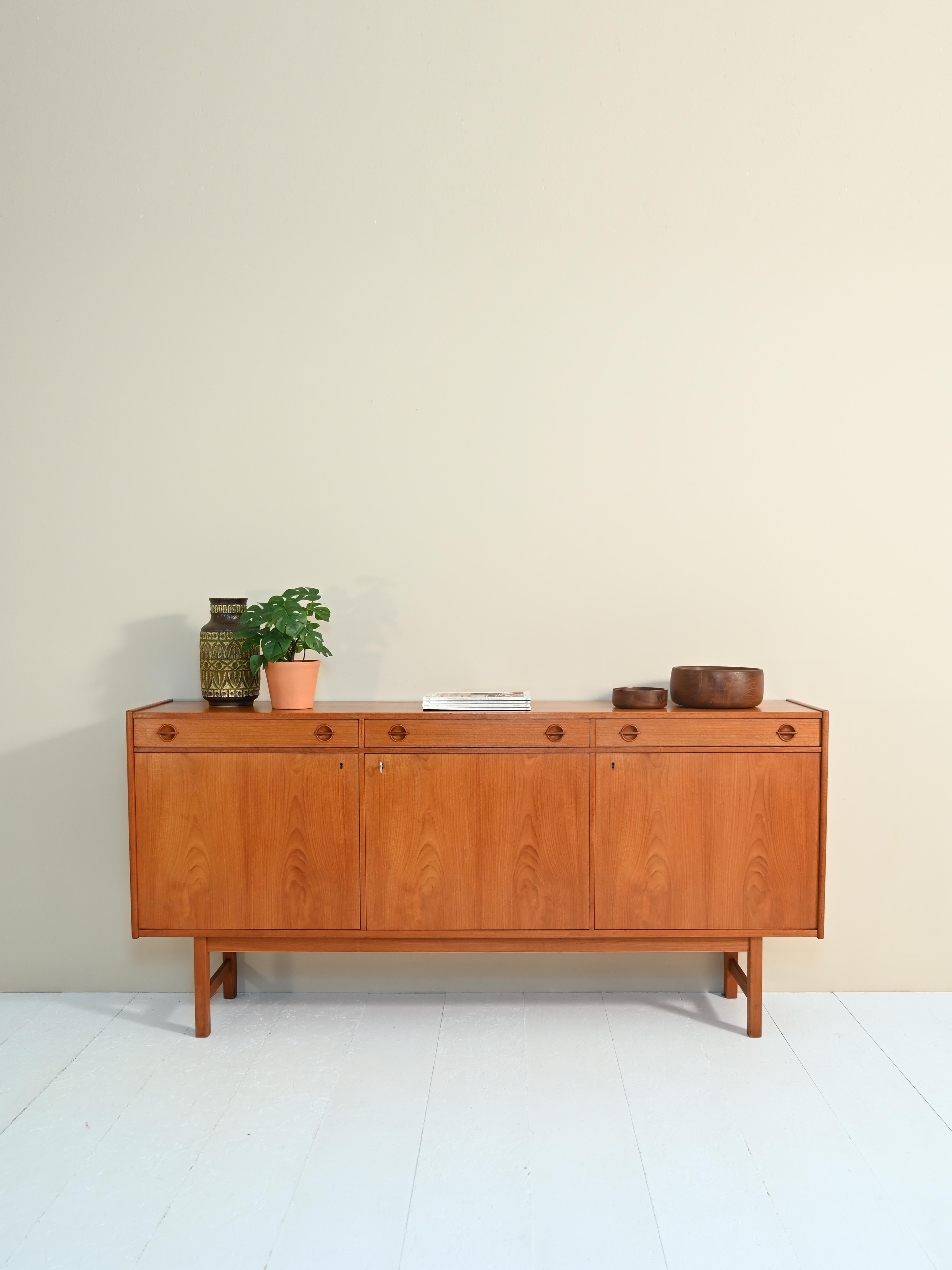 Original vintage 1950s sideboard of Scandinavian origin.
 
Divided into three equal parts consisting of a drawer under which is a compartment equipped with a shelf.

Scandinavian workmanship is evidenced by the attention to detail such as the