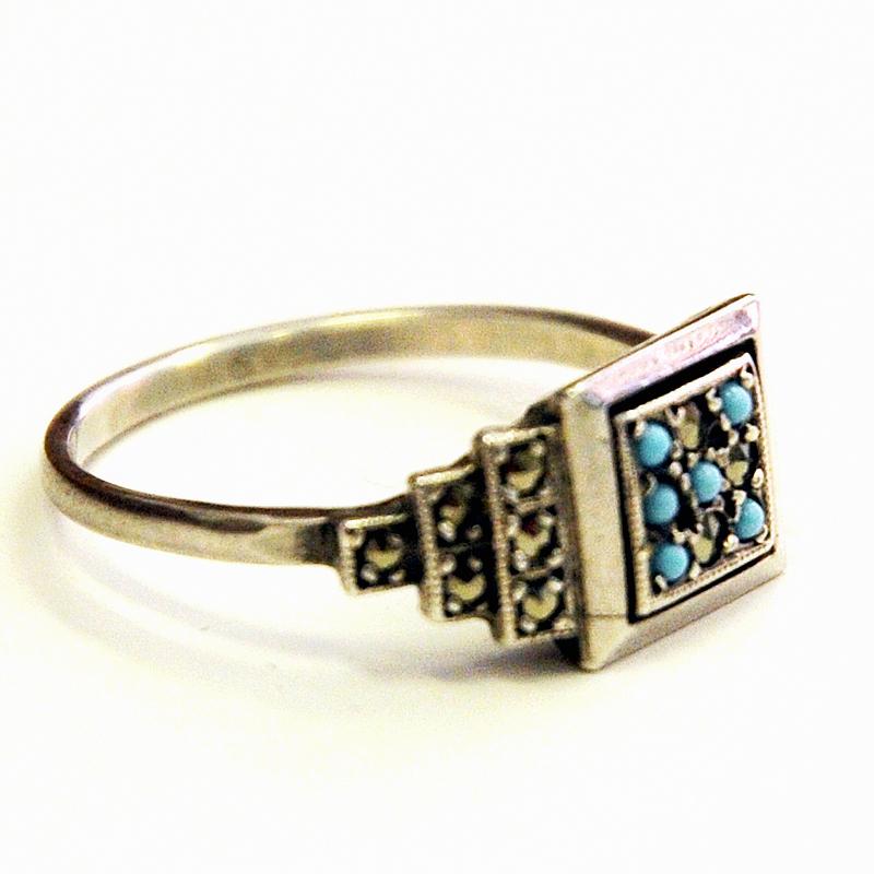 Rare and really lovely vintage silvering with a square front of small light blue and clear sparkling stones. Levels on the sides with clear stones. 

Stamped: Sterling. Measures: 21 mm D, total height of ring 24 mm. Size of square: 10 mm x 10 mm.