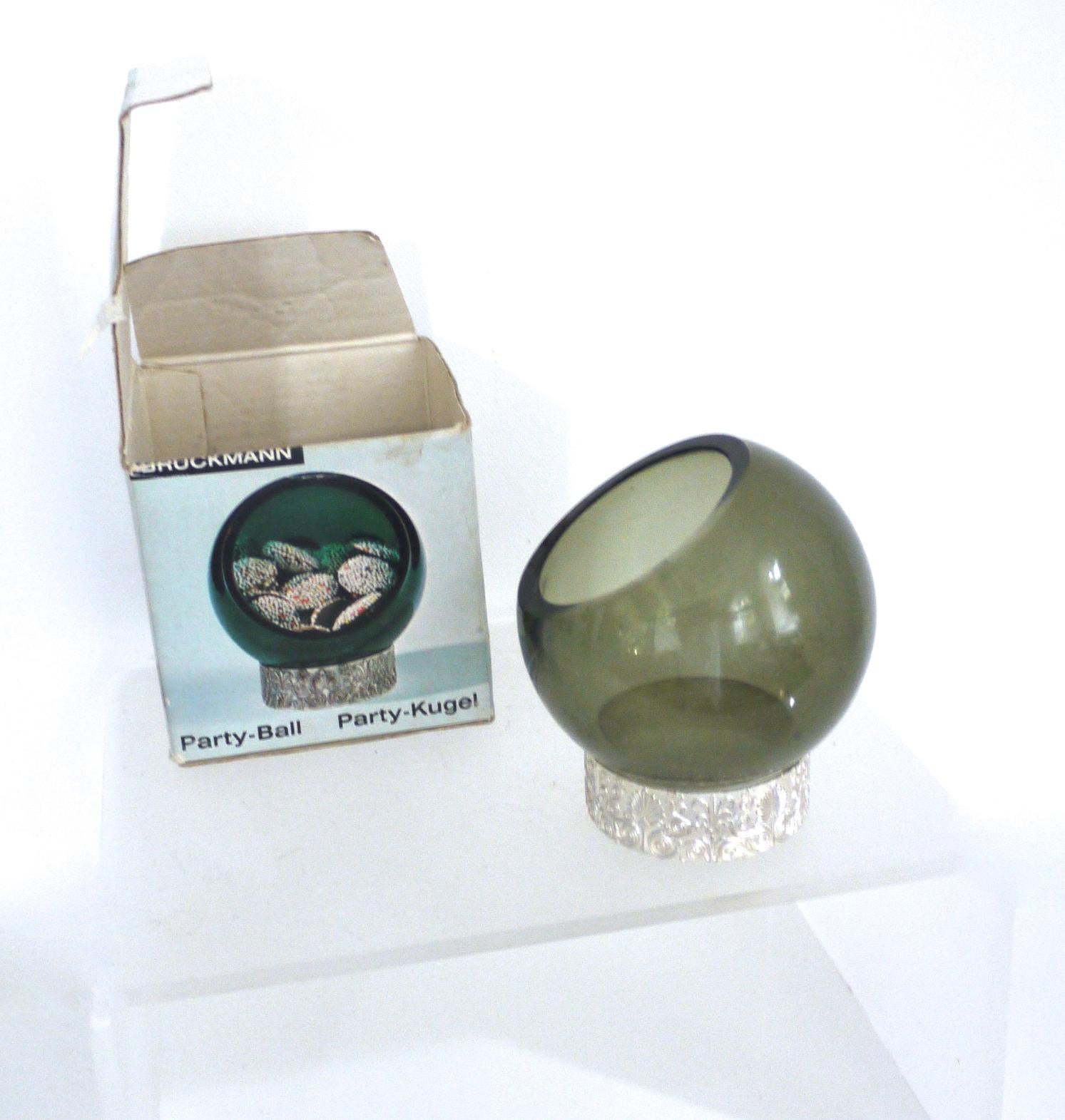 Scandinavian smoked glass Party Kugel for sweets or cigarettes new in box 1960s. Party Kugel means 'Party Ball' New in box. Made by Bruckmann

This piece is a perfect gift for Christmas - silver plated 'mount' with smoked sphere glass bowl (small