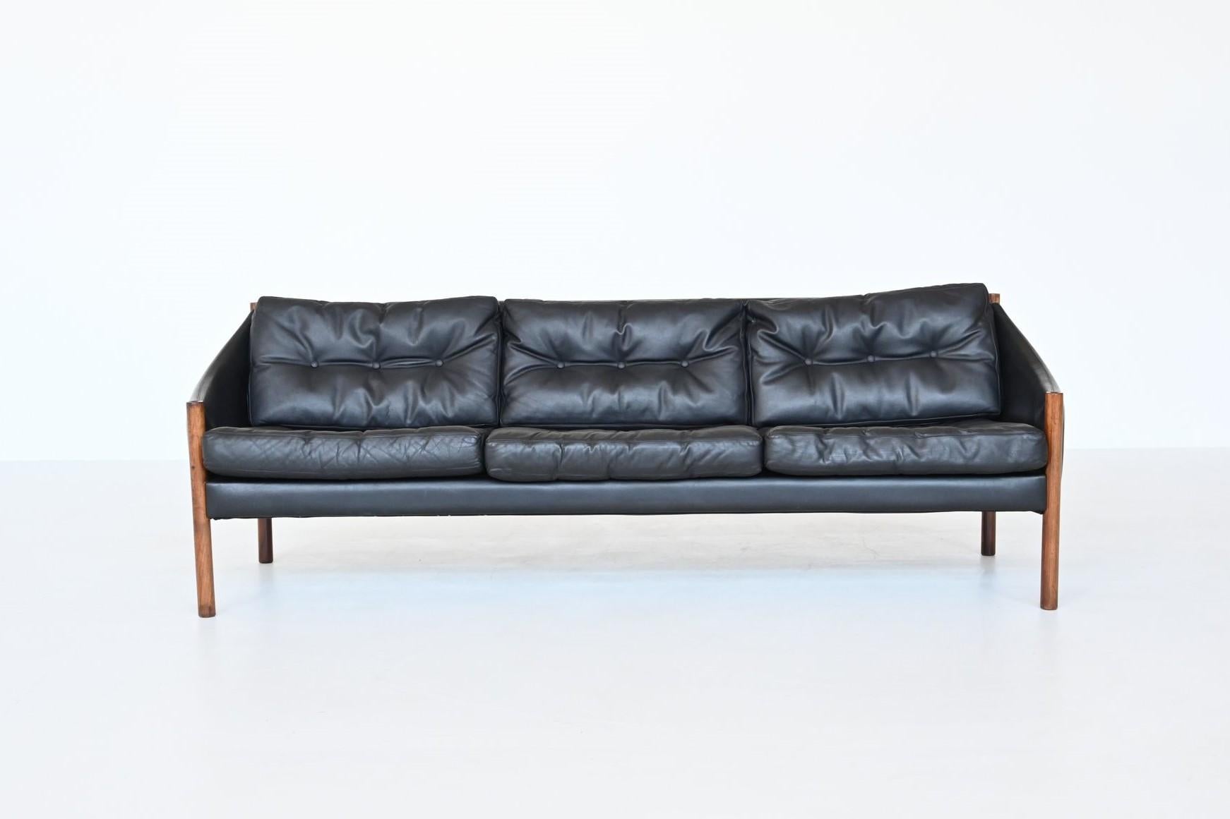 Beautiful shaped Scandinavian lounge sofa, Denmark 1960. This unique three-seater sofa has a solid rosewood frame with black leather upholstery. Very nice details are the well-crafted legs and high quality original leather. This amazing sofa is