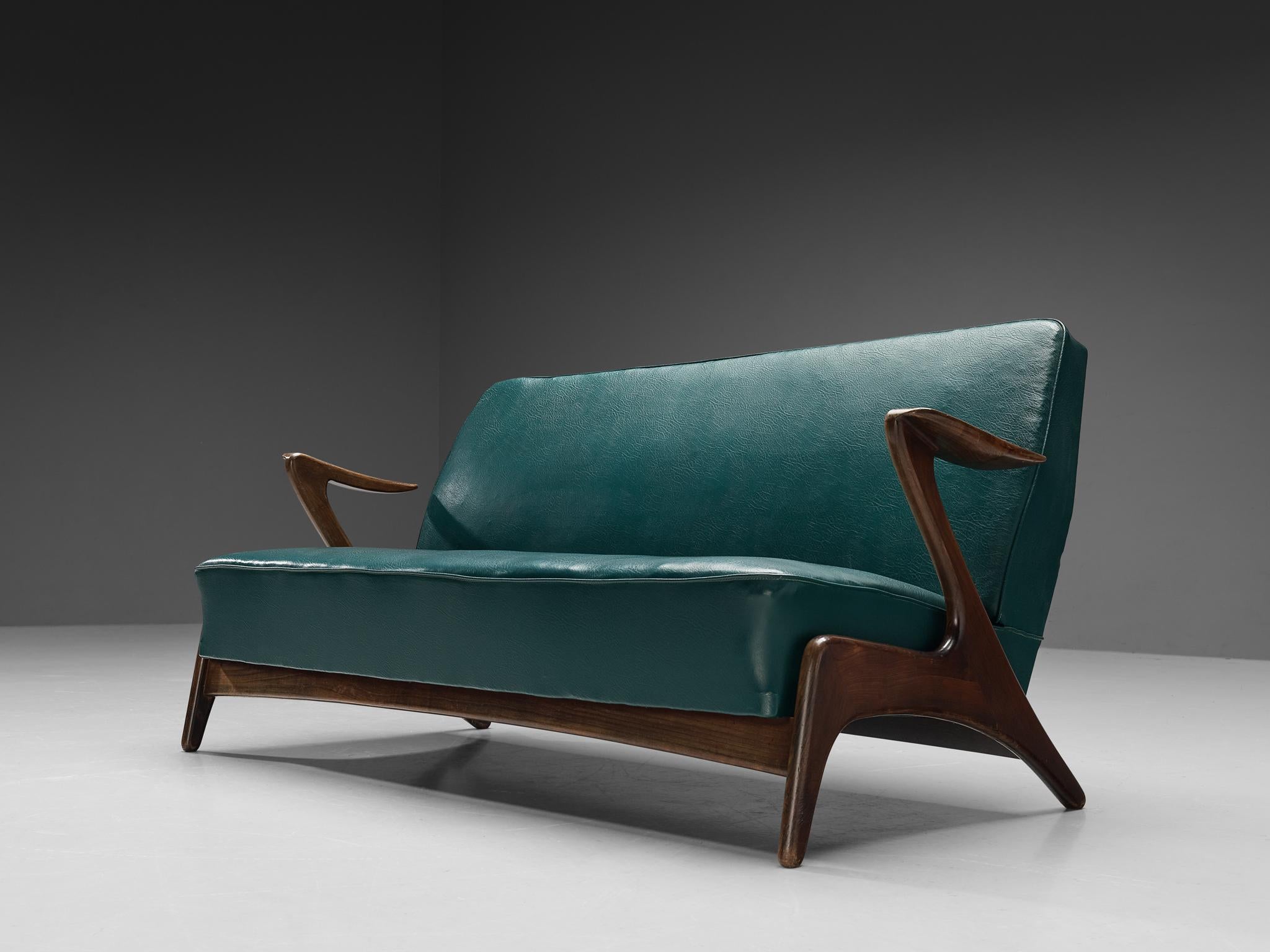Sofa, leatherette, stained wood, Scandinavia, 1960s 

This sofa embodies a splendid construction based on curvaceous lines and round corners. The wooden armrests and legs are organically built featuring a subtle motion established by slightly