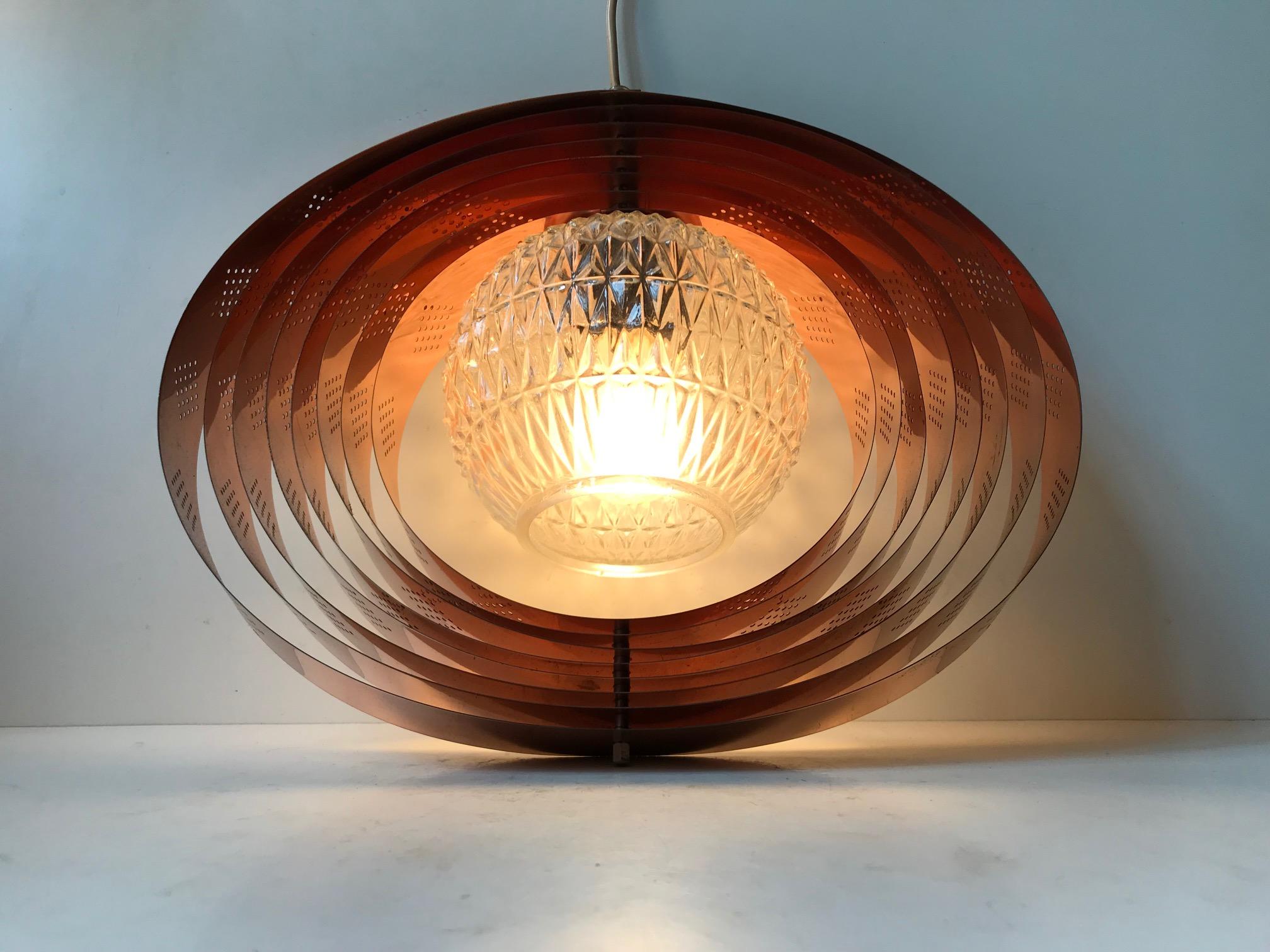 A rare Danish hanging light composed of rotating/modular copper rings and a centre shade in pressed glass. This Space Age design enables you to create a variety of different shapes. The most obvious ones being a moon or the outlines of the planet