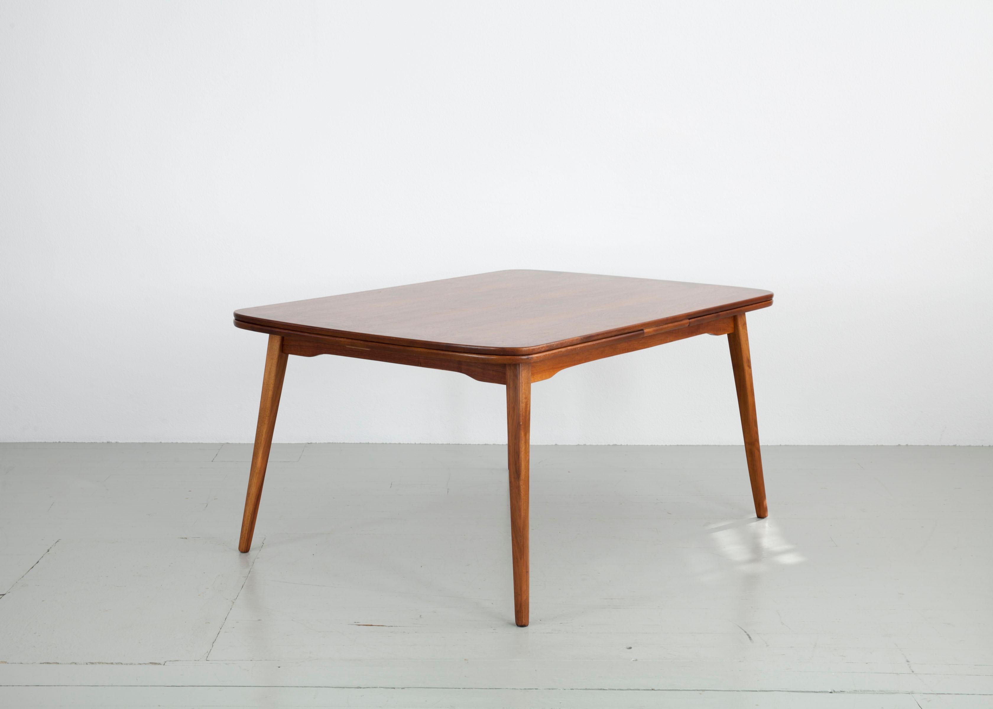 The design of this table frame made of solid stained beech is inspired by Scandinavian forms. The table has an extendable tabletop with rosewood veneer. Either one or both sides can be extended. The table is in very good vintage condition.

Do not