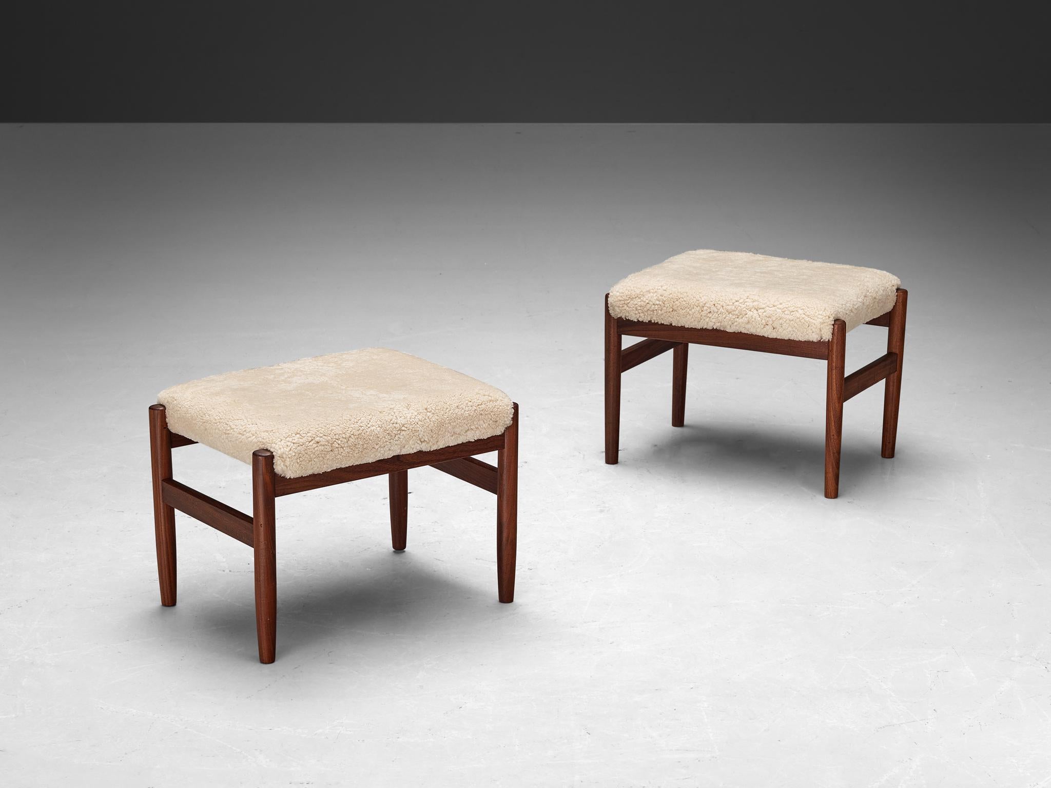 Ottomans or stools, Scandinavia, teak, shearling upholstery, 1960s

Exhibiting a timeless blend of simplicity and functionality, these stools epitomize the understated elegance characteristic of Mid-Century Scandinavian design. Crafted from teak,