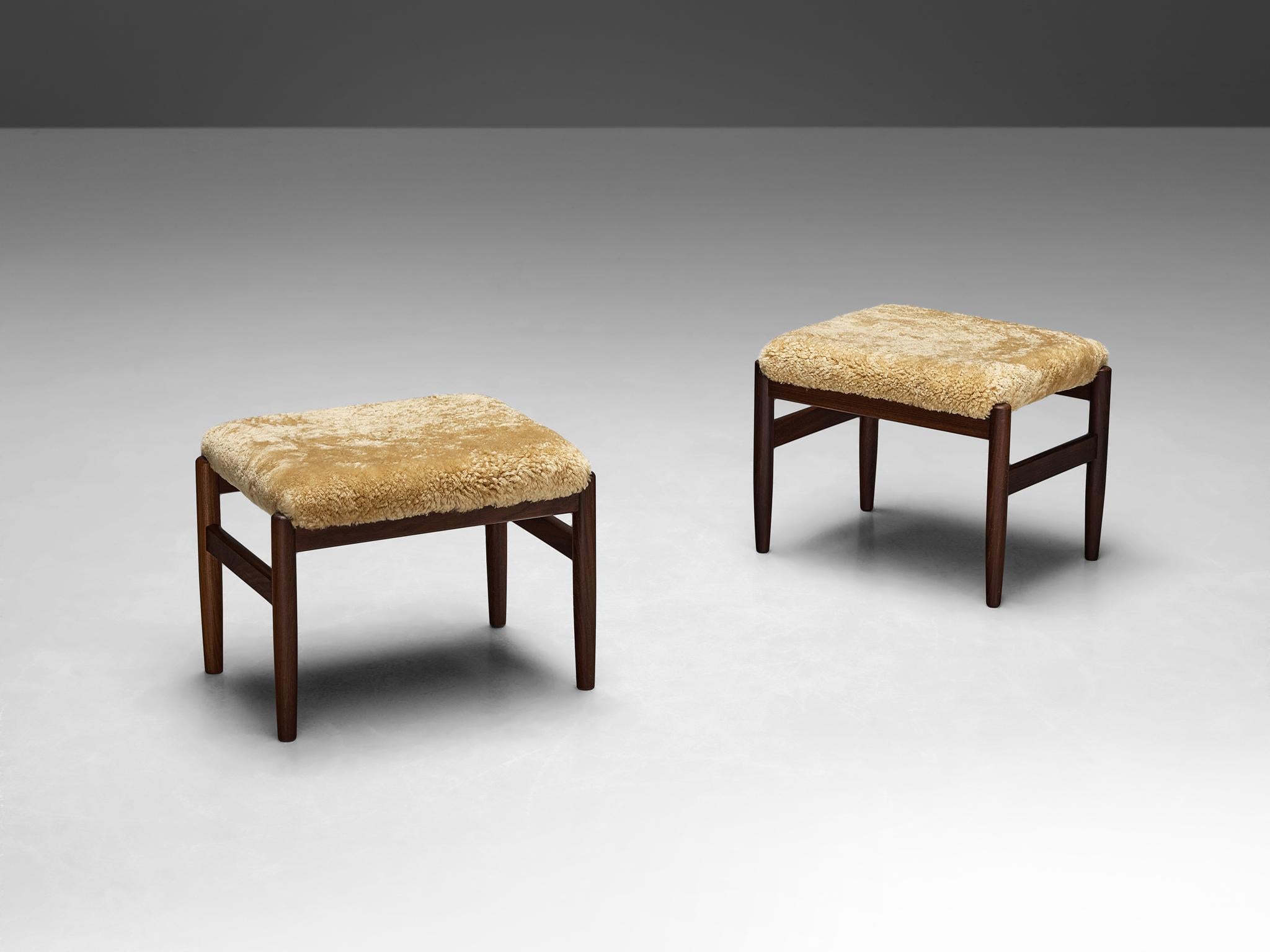 Ottomans or stools, Scandinavia, teak, shearling upholstery, 1960s

Exhibiting a timeless blend of simplicity and functionality, these stools epitomize the understated elegance characteristic of Mid-Century Scandinavian design. Crafted from teak,