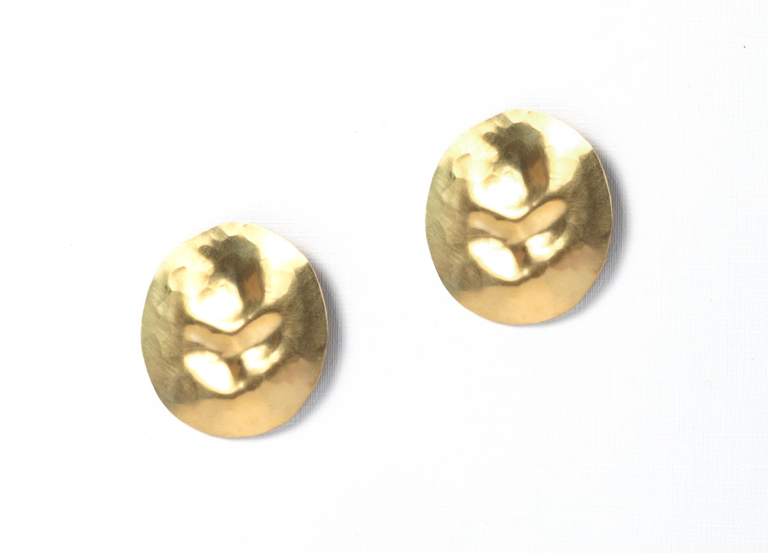 Circular stud earrings in hammered brass. Named Collapsed, designed and hand made by silversmith Hedvig Sommerfeldt. Both earrings are in excellent condition. 