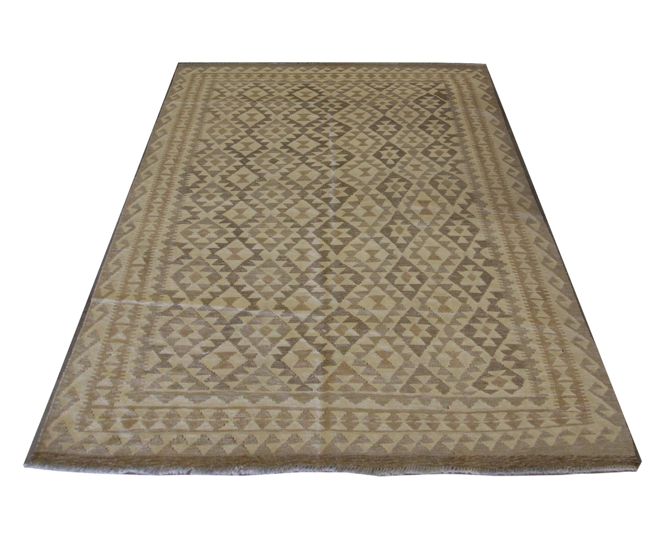 This Kilim is a new traditional area rug woven by hand in Afghanistan. The central pattern is well balanced, symmetrically woven with a subtle Scandinavian rug colour palette including cream, brown and beige. The geometric motif main design has then