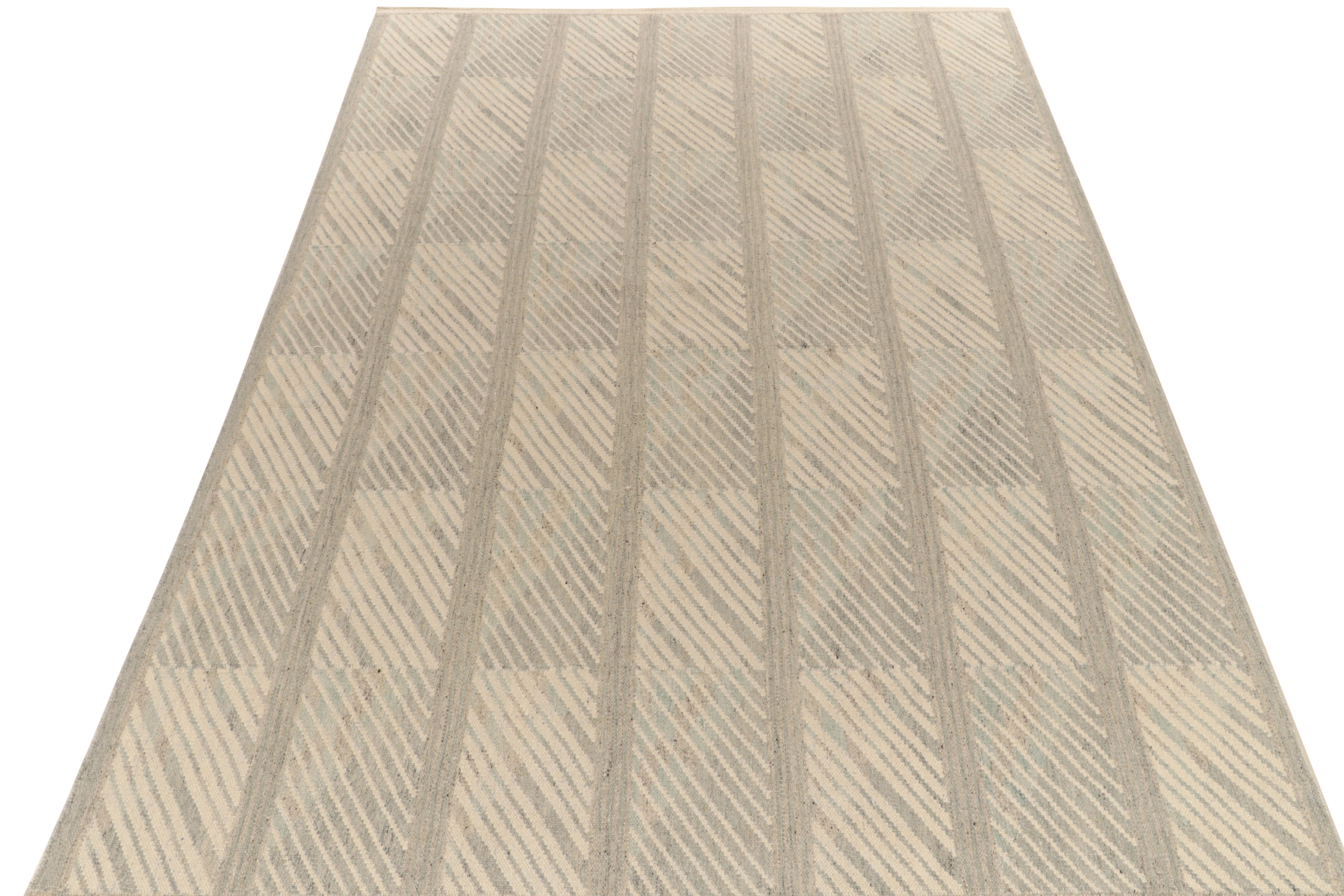 Handwoven in fine quality wool, a 10x14 Kilim joining our award-winning Scandinavian flat weave textures. The contemporary rug features a sharp geometric Deco pattern with striations in gray & beige for reflective, yet comfortable movement in fine