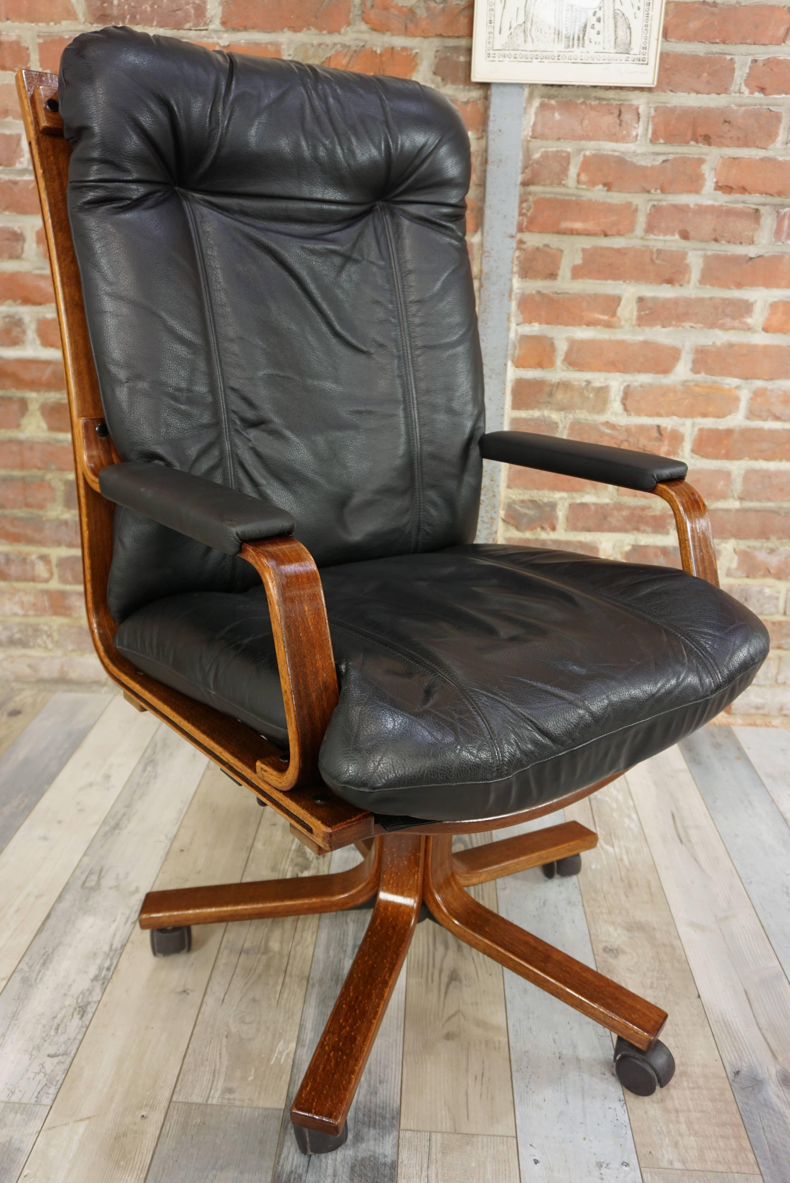 This practical and ergonomic swivel office armchair with leather (armrests in black faux - leather) seat and wooden structure, star feet is in excellent state. High French quality, swivel (system allowing the return to the initial position) and