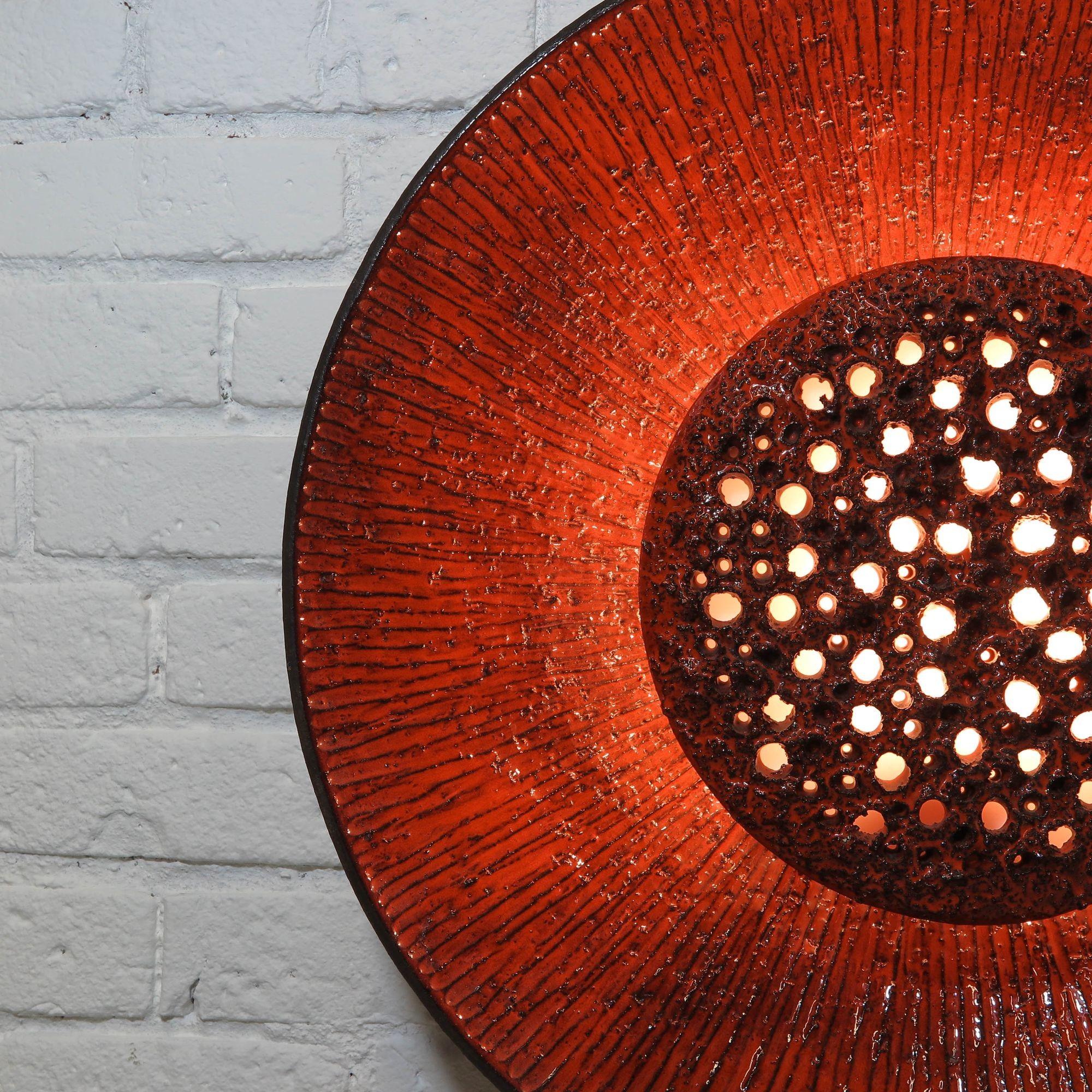 Stunning Danish ceramic wall light by Sejer Keramikfabrik, 1960s, Denmark. The light features a deep orange/red glaze over round discs which illuminates light through to create ambient 