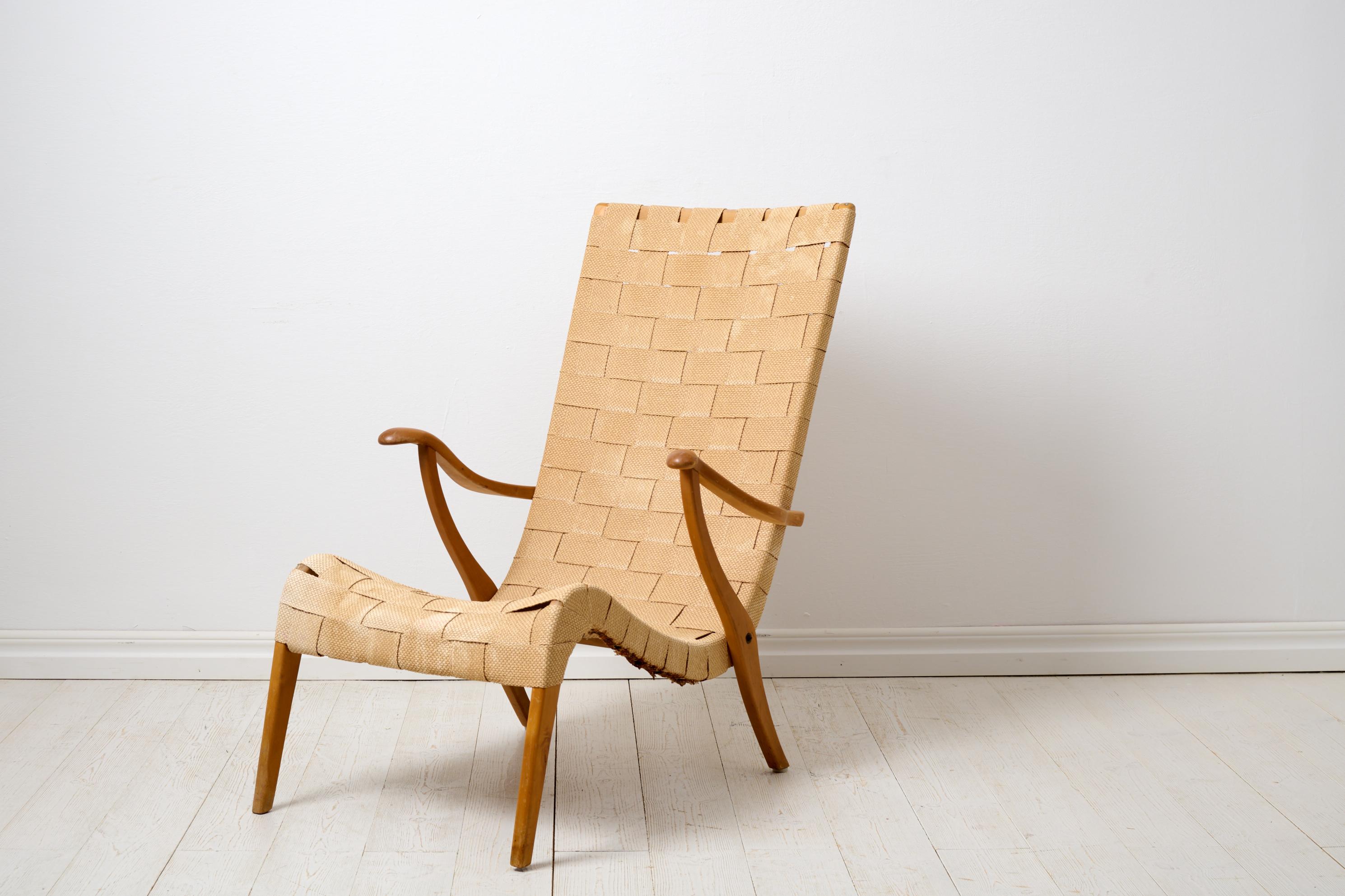 Vintage Axel Larsson armchair for Svenska Möbelfabrikerna Bodafors. The chair is a Scandinavian Swedish modern furniture, designed in 1937 and this one was made during the late 1930s or 1940s. Original straps and weaving, with some traces of use.