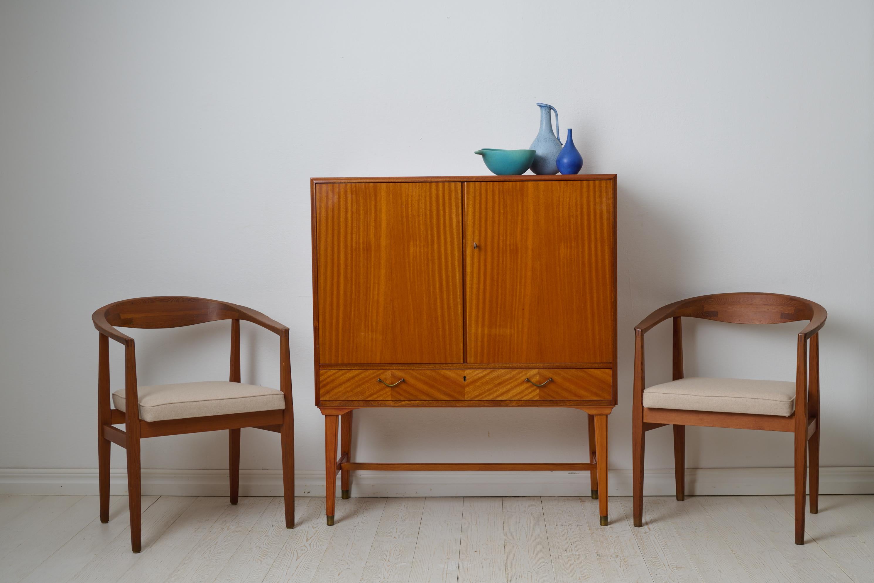 Armoire suédoise moderne et vintage du milieu du 20e siècle. Fabriqué en Suède et plaqué d'acajou. Style simple et élégant caractéristique du milieu du siècle dernier. Quincaillerie en laiton, serrure et clé en état de marche. Bon état vintage avec