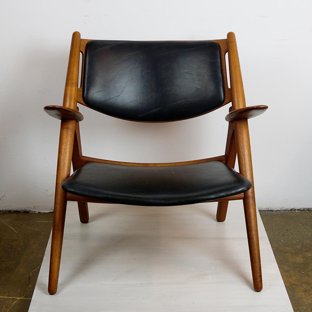 Questa iconica sedia scandinava in teak è stata progettata negli anni '50 dal famoso designer danese Hans Wegner e conosciuta universalmente come Sawback Chair. 
È prodotto da Carl Hansen Danimarca, Model No. CH28. 
Presenta una struttura in Teak