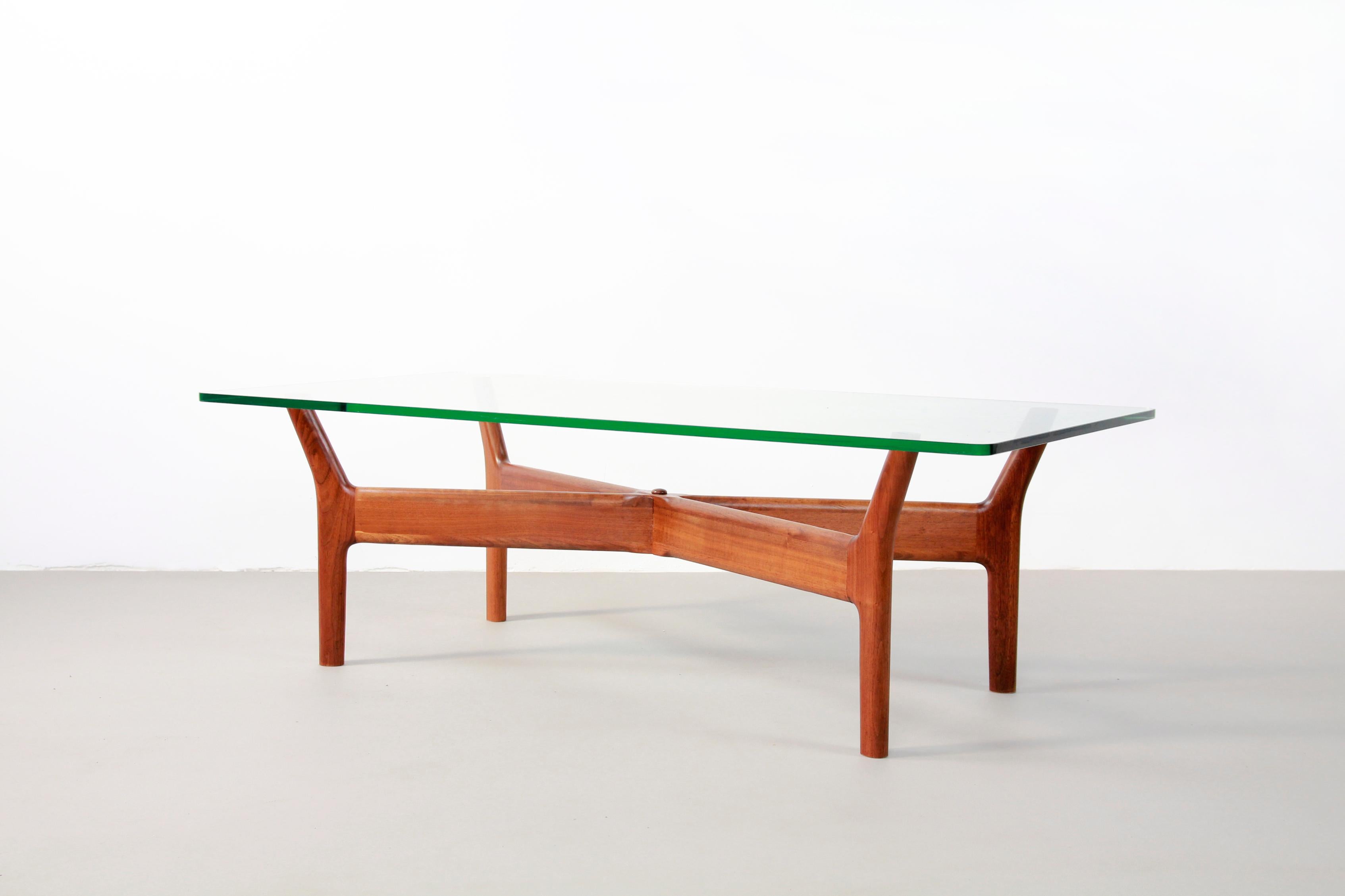 Beautiful and rare coffee table designed by Alf Svensson and produced by Bra Bohag from Sweden in 1956. The table consists of a teak wooden frame and a 2.5 cm thick glass top. The combination between the organic shapes and the glass top is