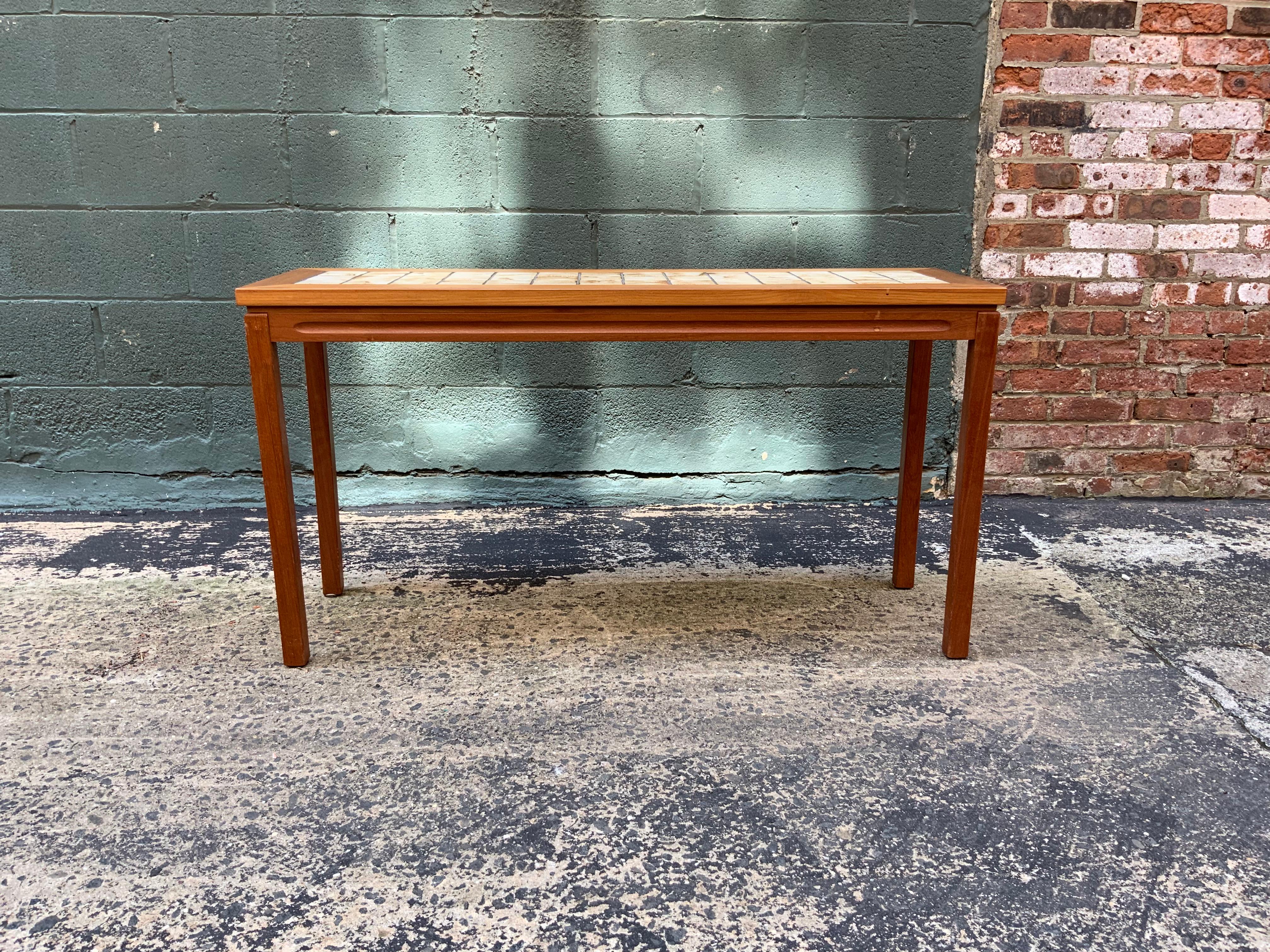 Perfect as a sofa table or hall console. Teak frame and legs with a tiled top. Mitered top corner detail, circa 1970-1980. Very good condition.