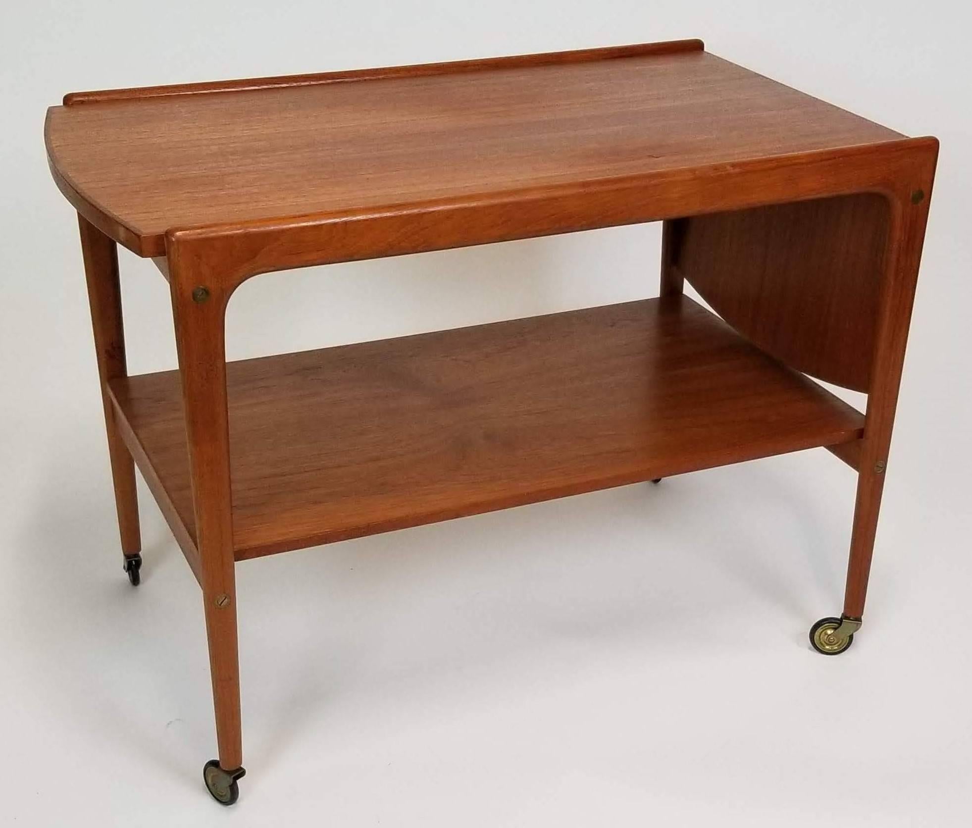 Midcentury Scandinavian Modern rolling teak tea trolley/bar cart by Yngve Ekström, made in Sweden. The cart has a drop-leaf top, which lifts and slides to expand. Open, the surface measures 42.5