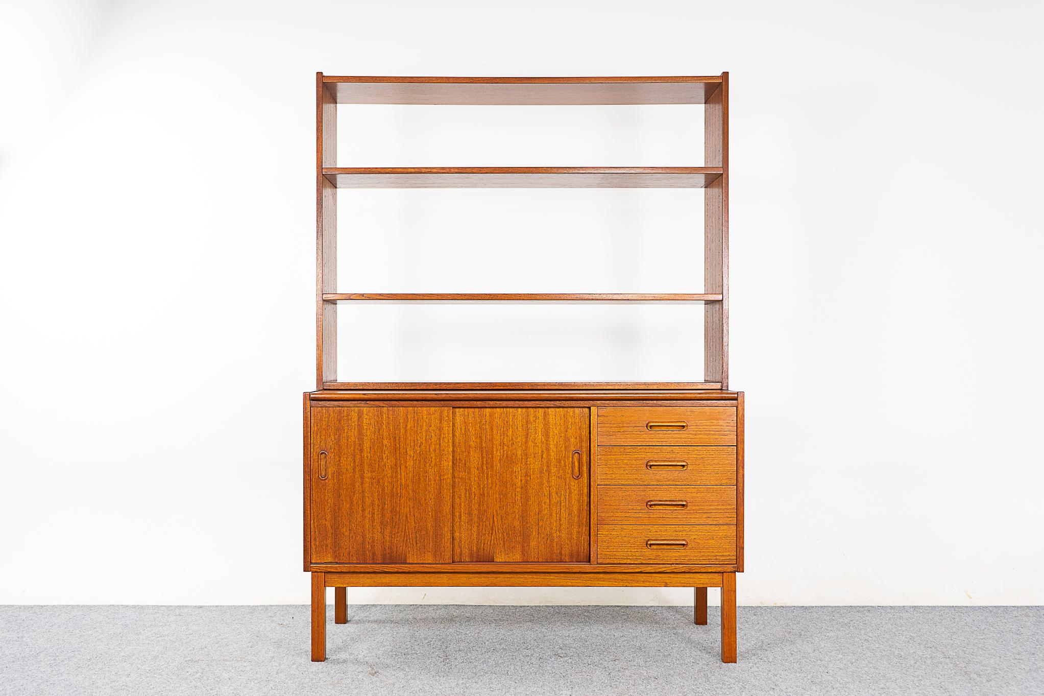 Teak mid-century bookcase/cabinet and desk, circa 1960's. Highly functional design combines drawers, sliding door storage, pull out desk and an open bookshelf. One compact footprint, with much versatility!  

Please inquire for remote and