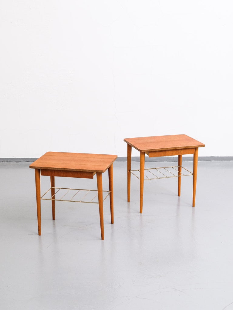 This set of two teak veneer bedside tables was made in Sweden during the 1950s. They have a drawer and a handy shelf of brass. The tapered legs are made of solid beech wood. This set is perfect match to modernist and classic trend.

Tables are in