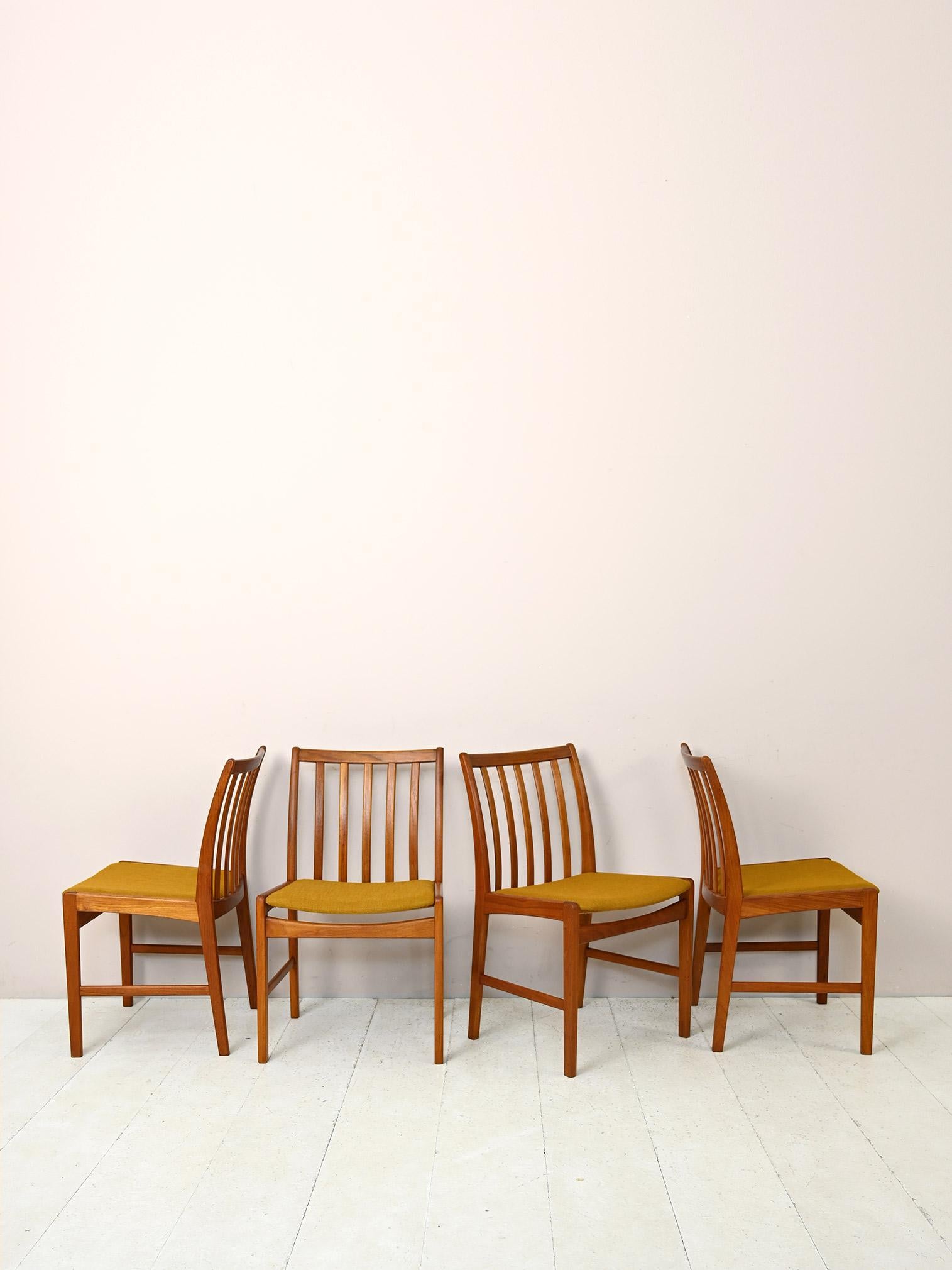 Ensemble de 4 chaises vintage originales des années 1960.

Composé d'un cadre en bois de teck et d'une assise légèrement rembourrée et retapissée de tissu ocre.
Les lignes modernes et élégantes renvoient au goût des Scandinaves pour le design simple