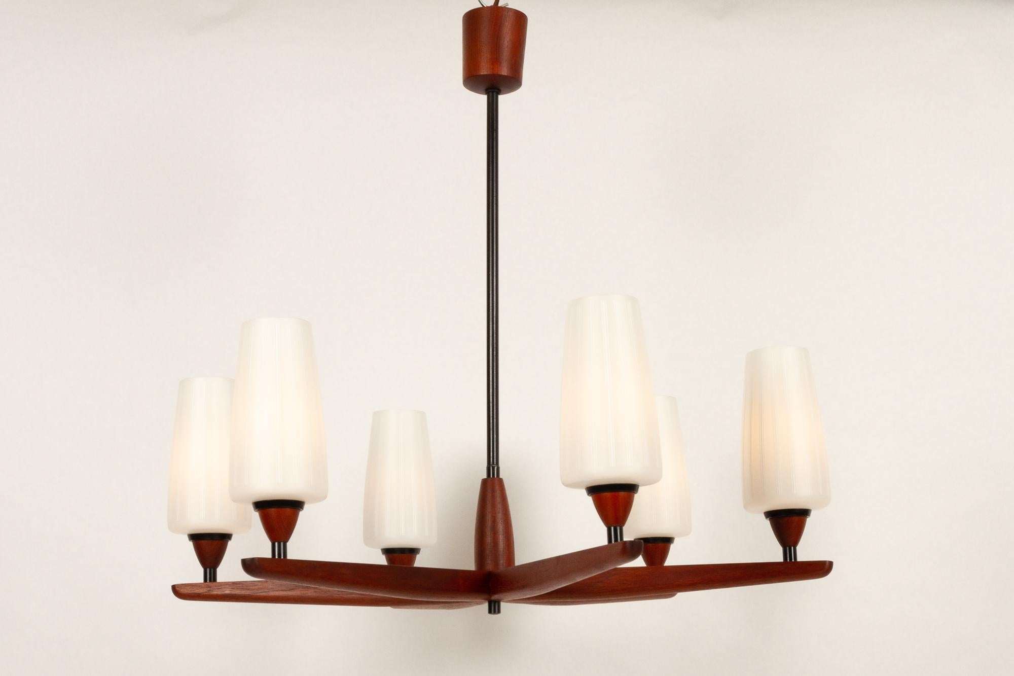 Scandinavian Modern 8-arm teak chandelier, 1950s.
Large Mid-Century Modern chandelier in solid teak with eight arms. Shades in frosted opaline glass with etched decorations. Emits a soft warm light. Possible to turn on either four or all eight