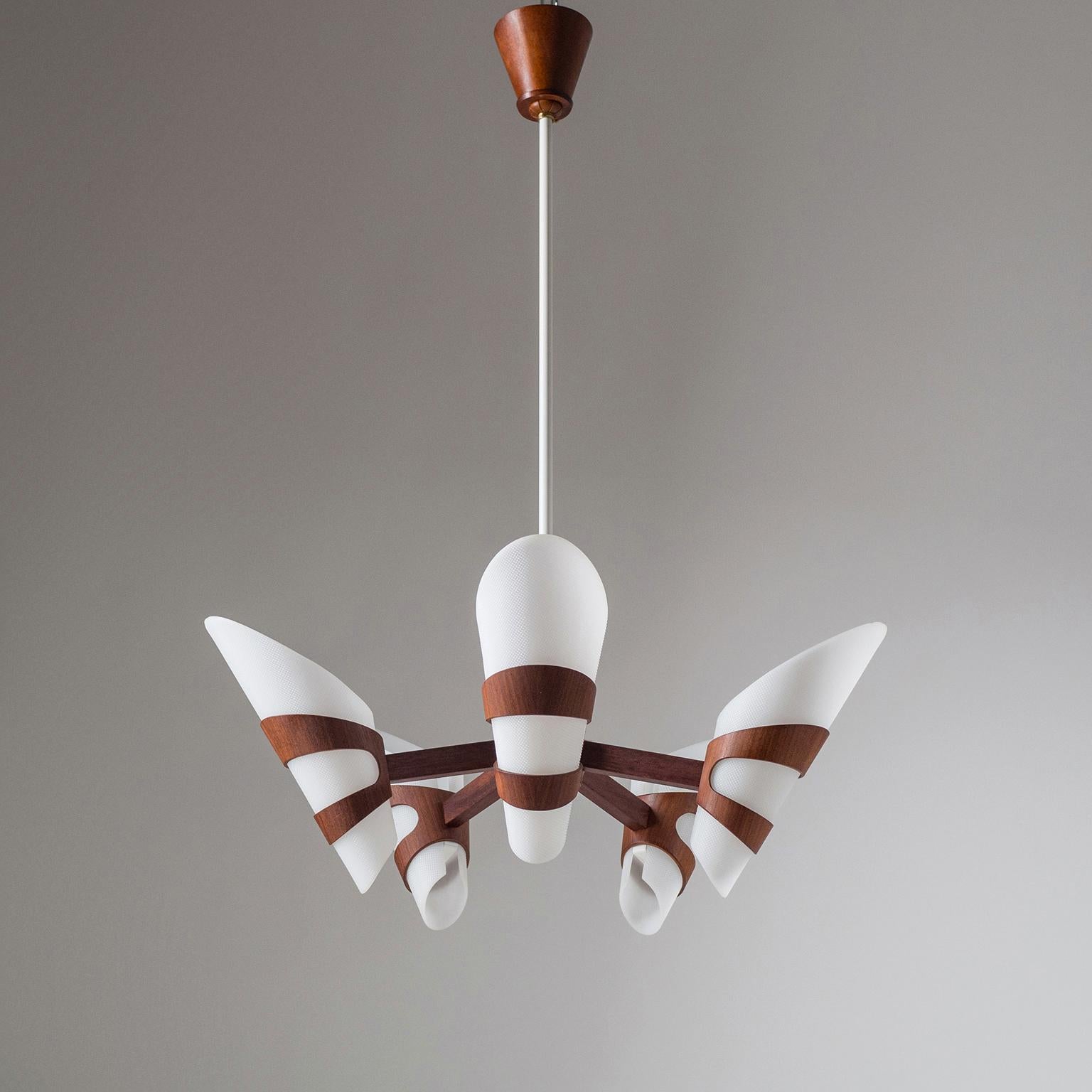 Rare graphical Scandinavian teak chandelier from the 1960s. The dark teak wood contrasted nicely with the cone shaped textured acrylic diffusers. White enameled stem with teak canopy. Very good condition with five original E14 sockets and new wiring.