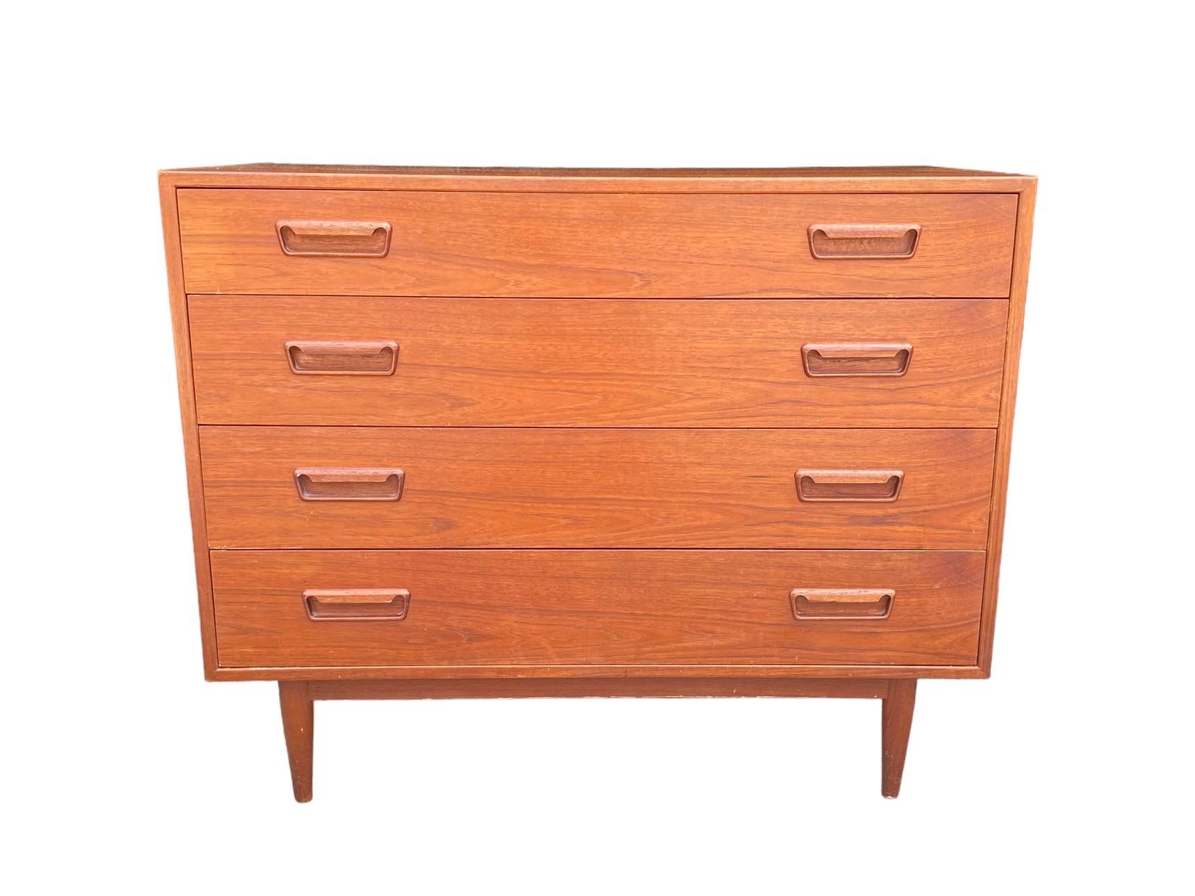 Excellent chest of drawers in teak wood with decorative angled pulls. Stamped Made in Norway. In the style of Arne Vodder. Stunning grain throughout the piece including the finished back panel. All four drawers pull and slide with ease. 
