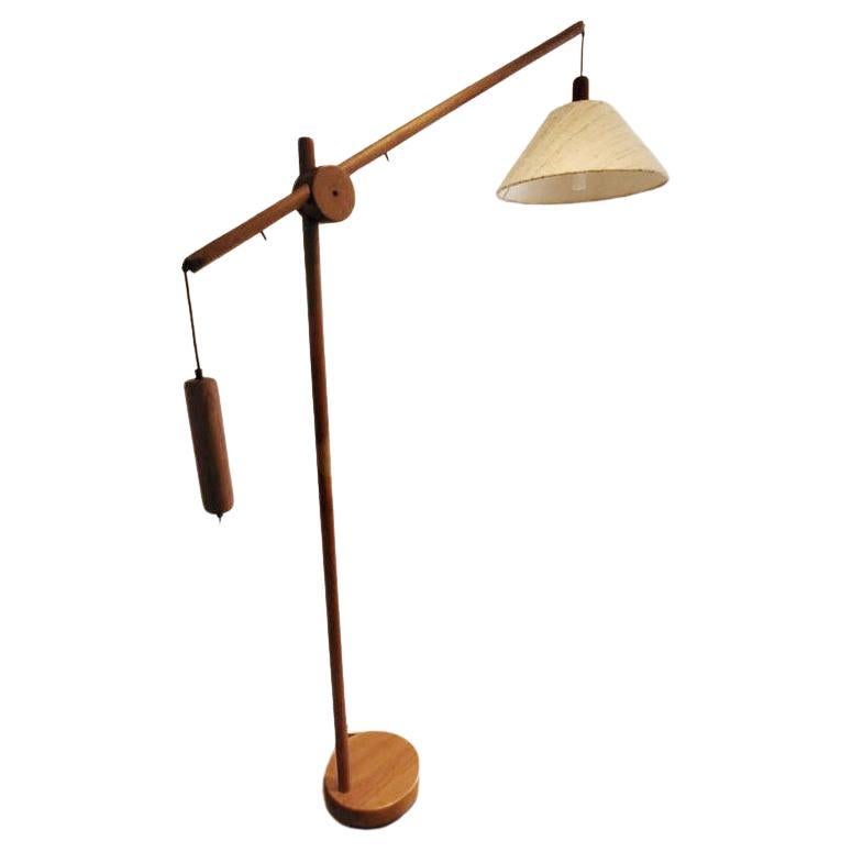 Tall Danish Mid-Century Modern floor lamp, produced around the early 1970's. The teak frame has an adjustable arm (with a length of 120 cm) and counterbalance weight for positioning of the light source. The lamp and counterweight move in opposite