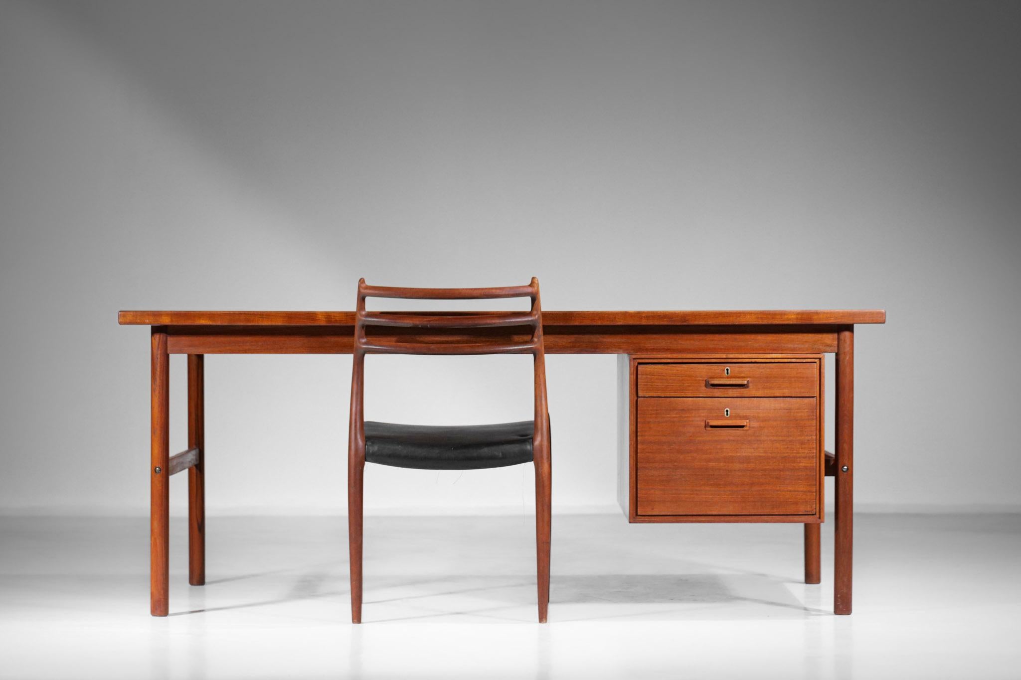 Scandinavian desk from the 1960s in the style of Kai Kristiansen's work. Structure in solid teak and teak veneer, consisting of a hanging cabinet with two drawers on one side and a shelf with a hinged door on the other and a retractable shelf. The