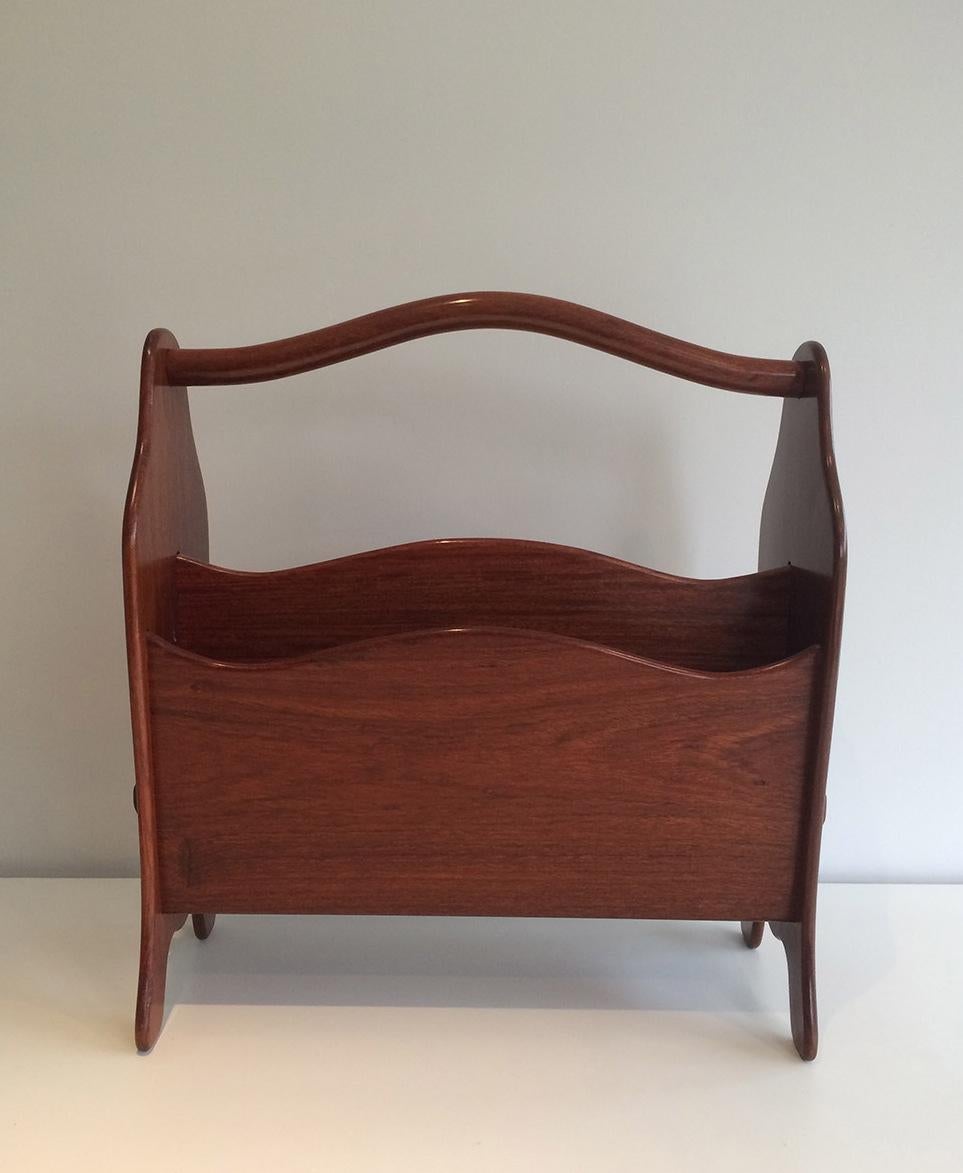 Questo portariviste è realizzato in teak esotico. Si tratta di un'opera francese del 1970 circa.