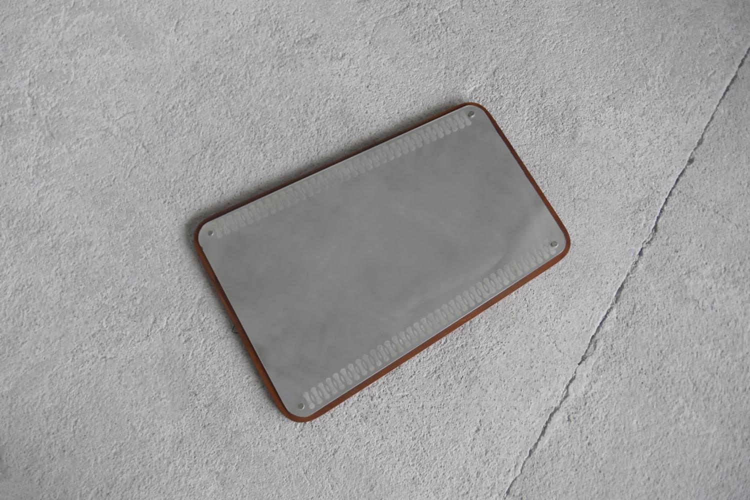 This wall mirror was made in Sweden during the 1950s. The glass pane is mounted on a solid teak frame. It has a decorative pattern on the glass. The slightly trapezoidal shape perfectly matching the Scandinavian design from the Mid Century Modern