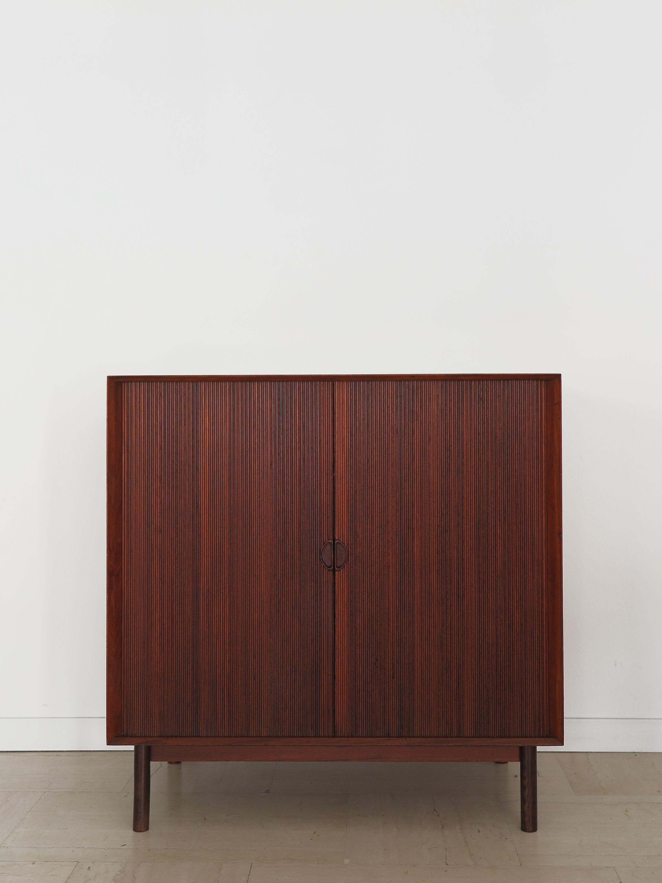 Scandinavian midcentury modern design teak credenza cabinet designed by Peter Hvidt & Orla Molgaard Nielsen for Soborg Mobelfabrik with sliding roller shutter doors and three internal shelves that can be positioned as desired, stamp of origin on the