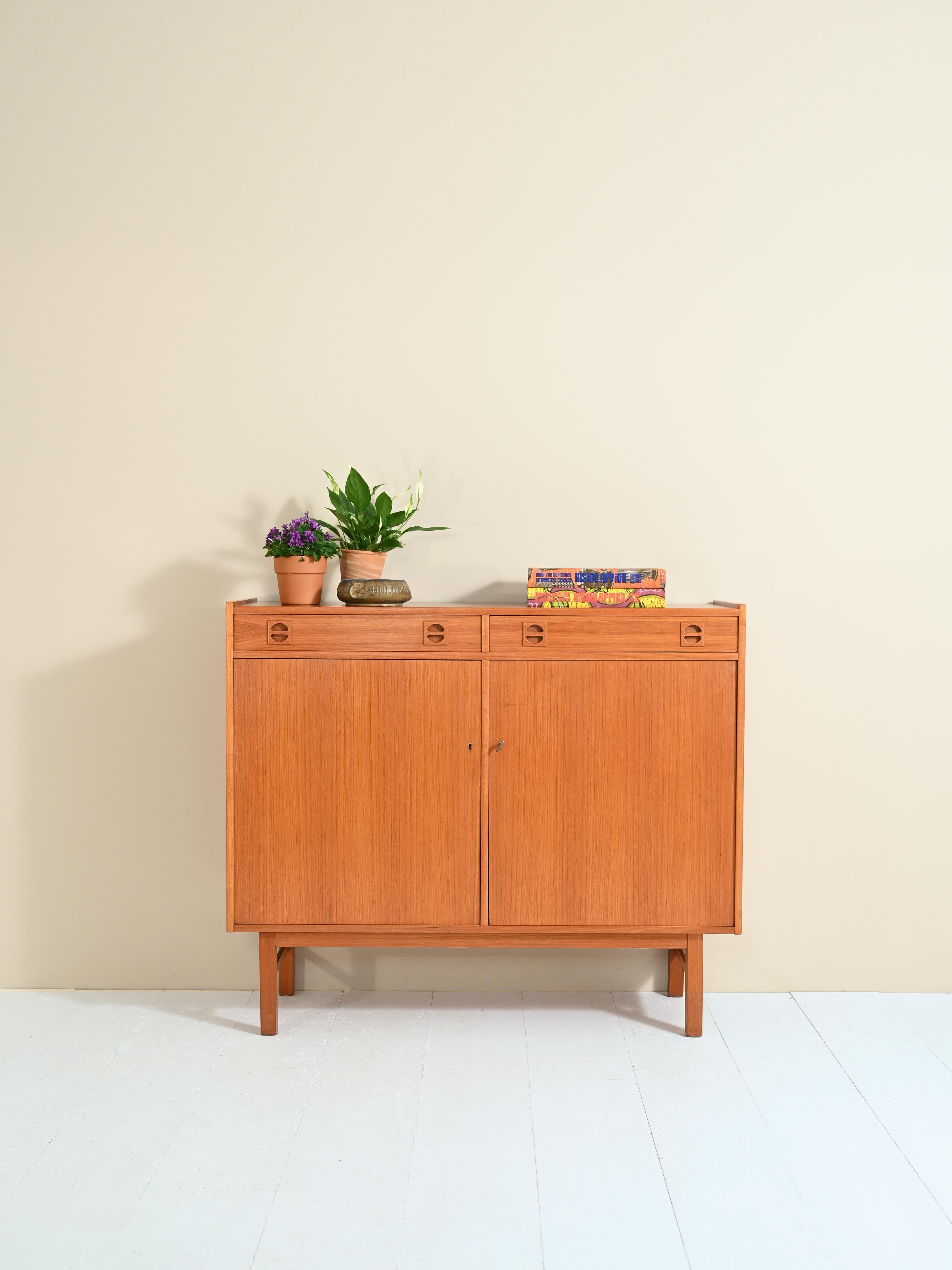 Original piece of furniture with doors and drawers.

Simple and functional, this capacious, small-sized cabinet is ideal for keeping the room tidy without sacrificing aesthetics.
Inside the storage compartment are two adjustable-height shelves.