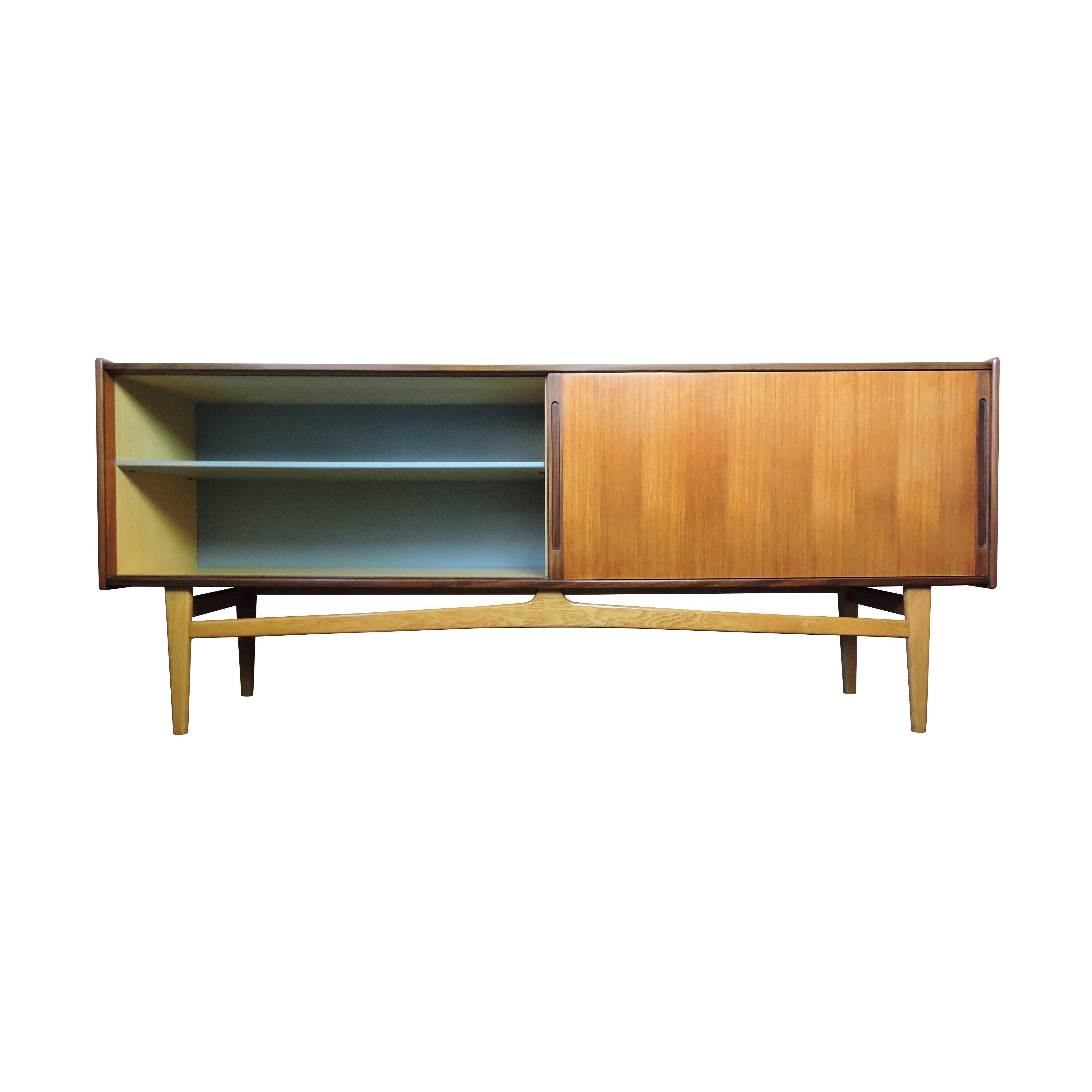 A Scandinavian teak sideboard made by Ulferts in the 1960s exclusively for Heals . Featuring multiple shelves and two drawers.